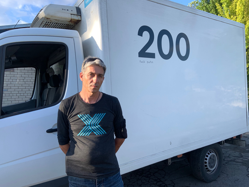 Oleg Repnoy stands in front of his Evacuation 200 vehicle. 'My job is to accompany these heroes on their last trip home,' he says.