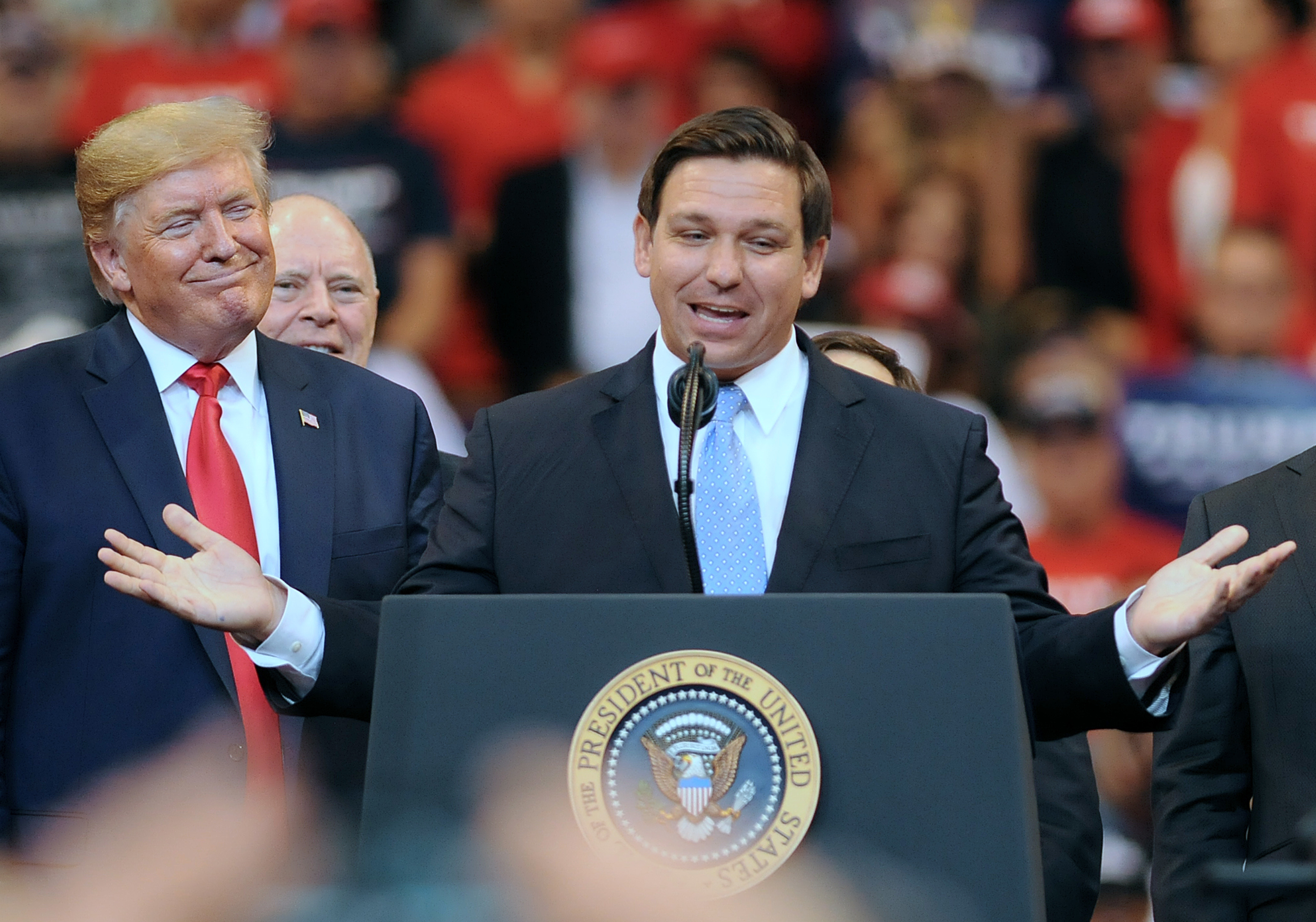 Then-President Donald Trump looks on as Florida Gov. Ron DeSantis speaks during the Florida Homecoming rally at the BB&T Center in 2019. (SOPA Images/LightRocket via Getty Images)