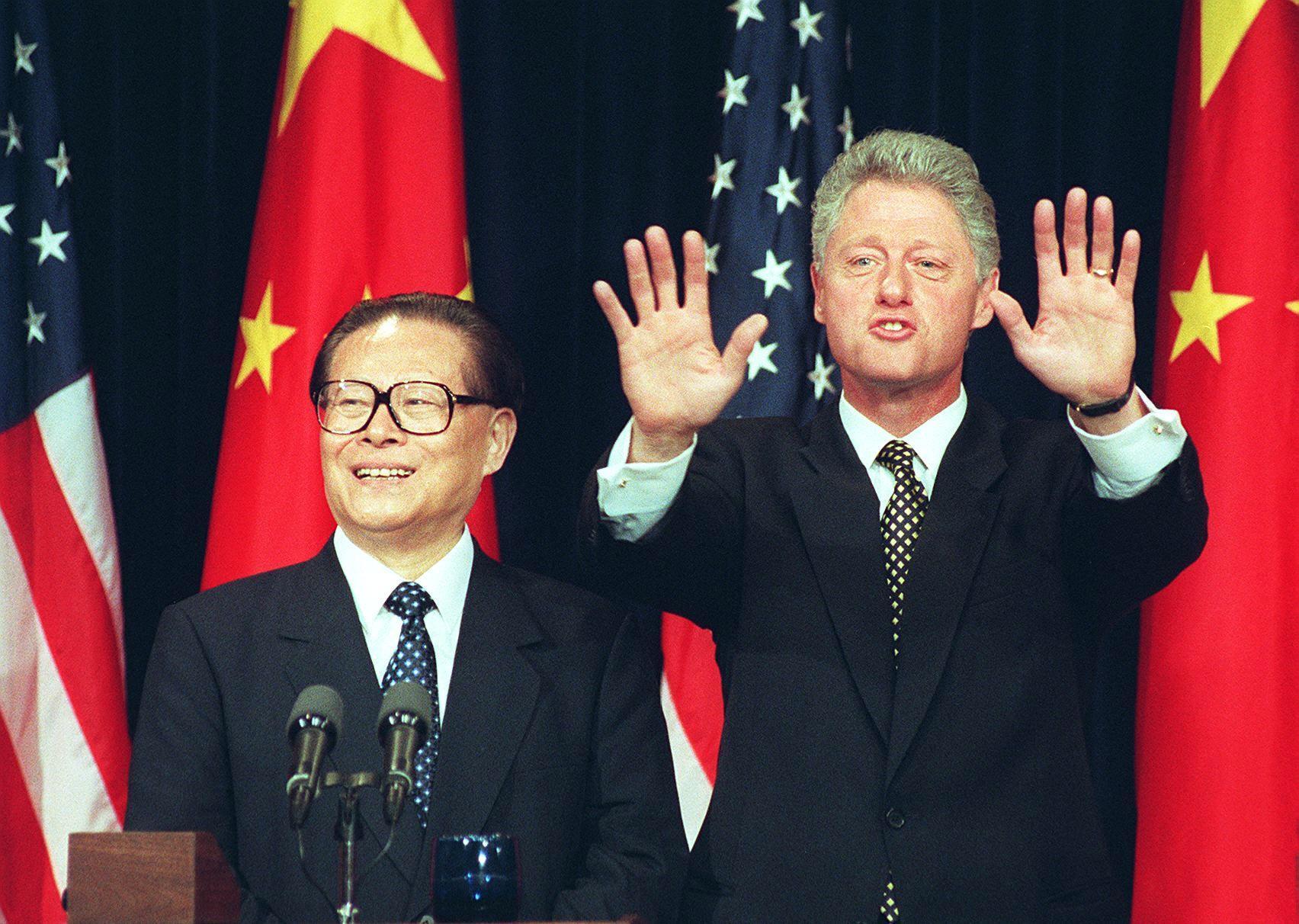 President Bill Clinton holds up his hands indicating no more questions as he and Chinese President Jiang Zemin hold a joint press conference in 1997 in Washington, D.C. Clinton confirmed that he agreed to lift a ban on the export of nuclear power technology to China. (AFP via Getty Images)