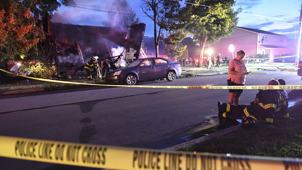 Firefighters on Friday set up lights in front of a fatal house fire in Nescopeck, Pa., that killed 10 people.