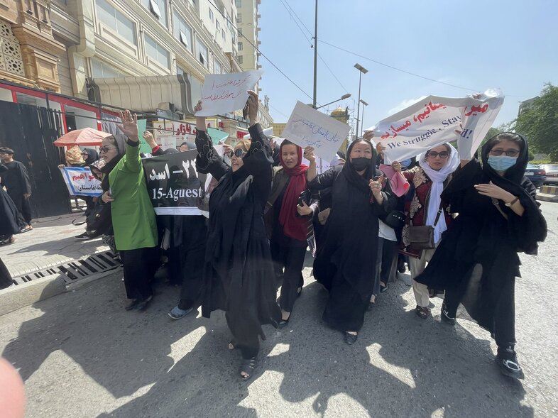 Women march down a main street in Kabul on Saturday, two days before the one-year anniversary of the Taliban takeover. (Diaa Hadid/NPR)