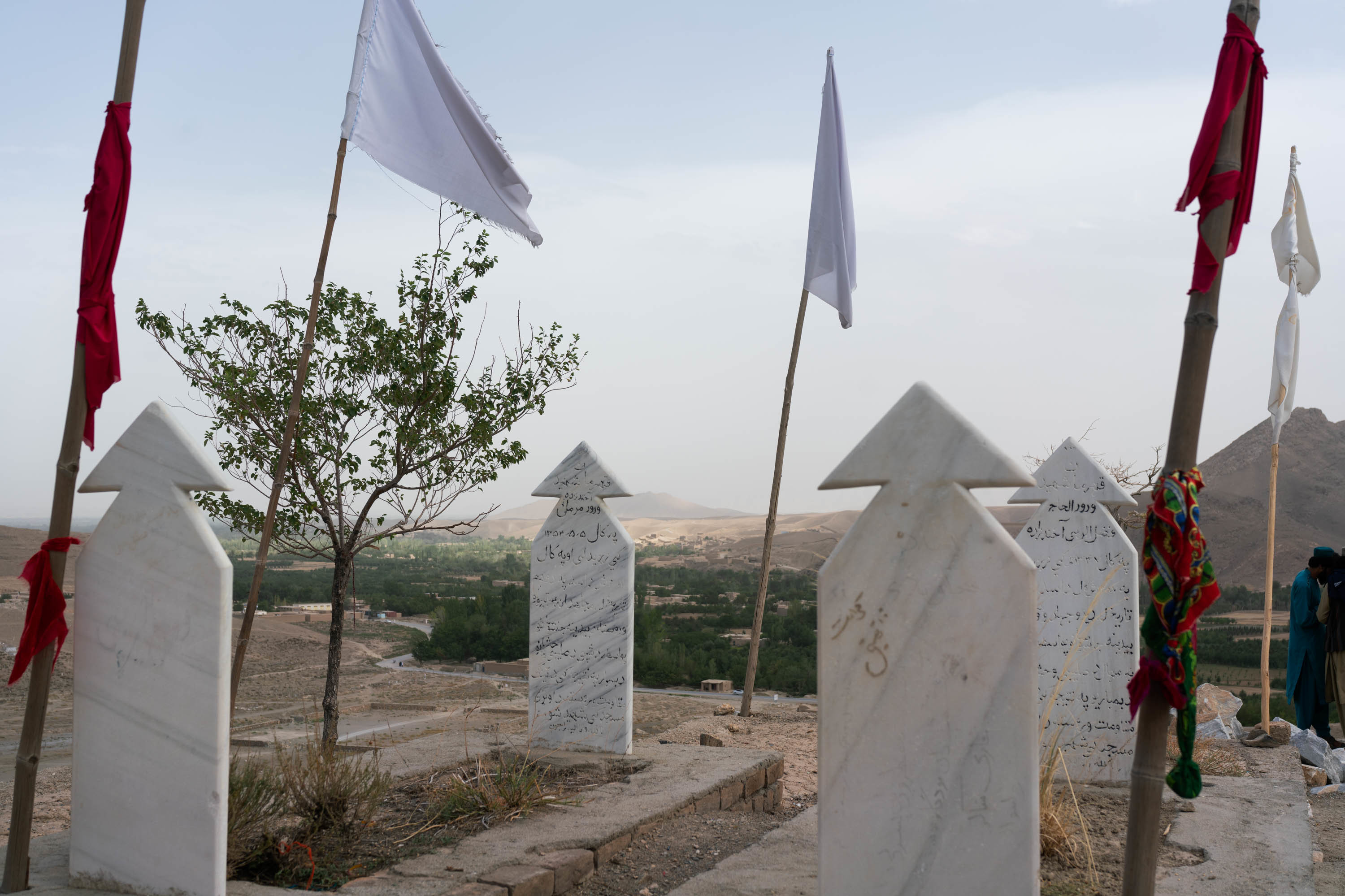 Afghans in a battle-scarred valley welcomed Taliban rule, but expect more 6 White flags stand over a shrine to the dead. Graves mark places for Mohammadi's brother and the late Taliban leader, Fazel Rabie.