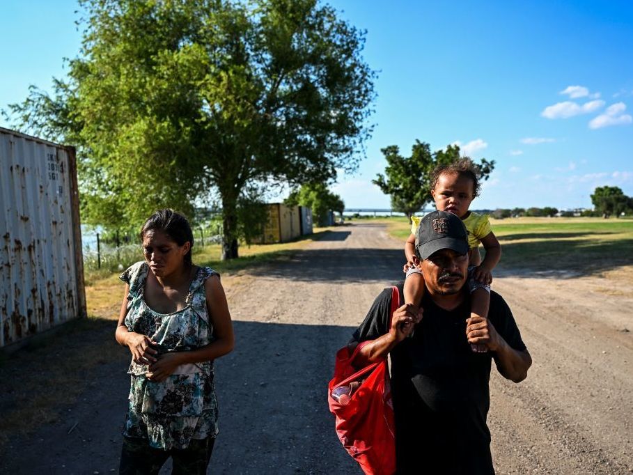 A migrant family is apprehended by U.S. Border Patrol agents and National Guard troops in Eagle Pass, Texas, near the border with Mexico on June 30, 2022. (AFP via Getty Images)