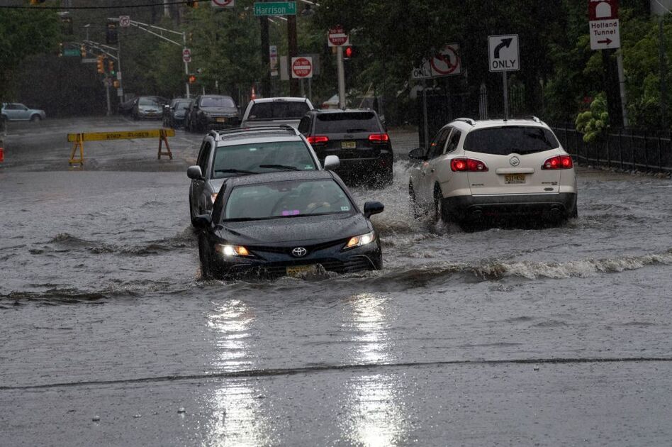 Cars drive on flooded streets as Tropical Storm Henri approaches, in Hoboken New Jersey on August 22, 2021.