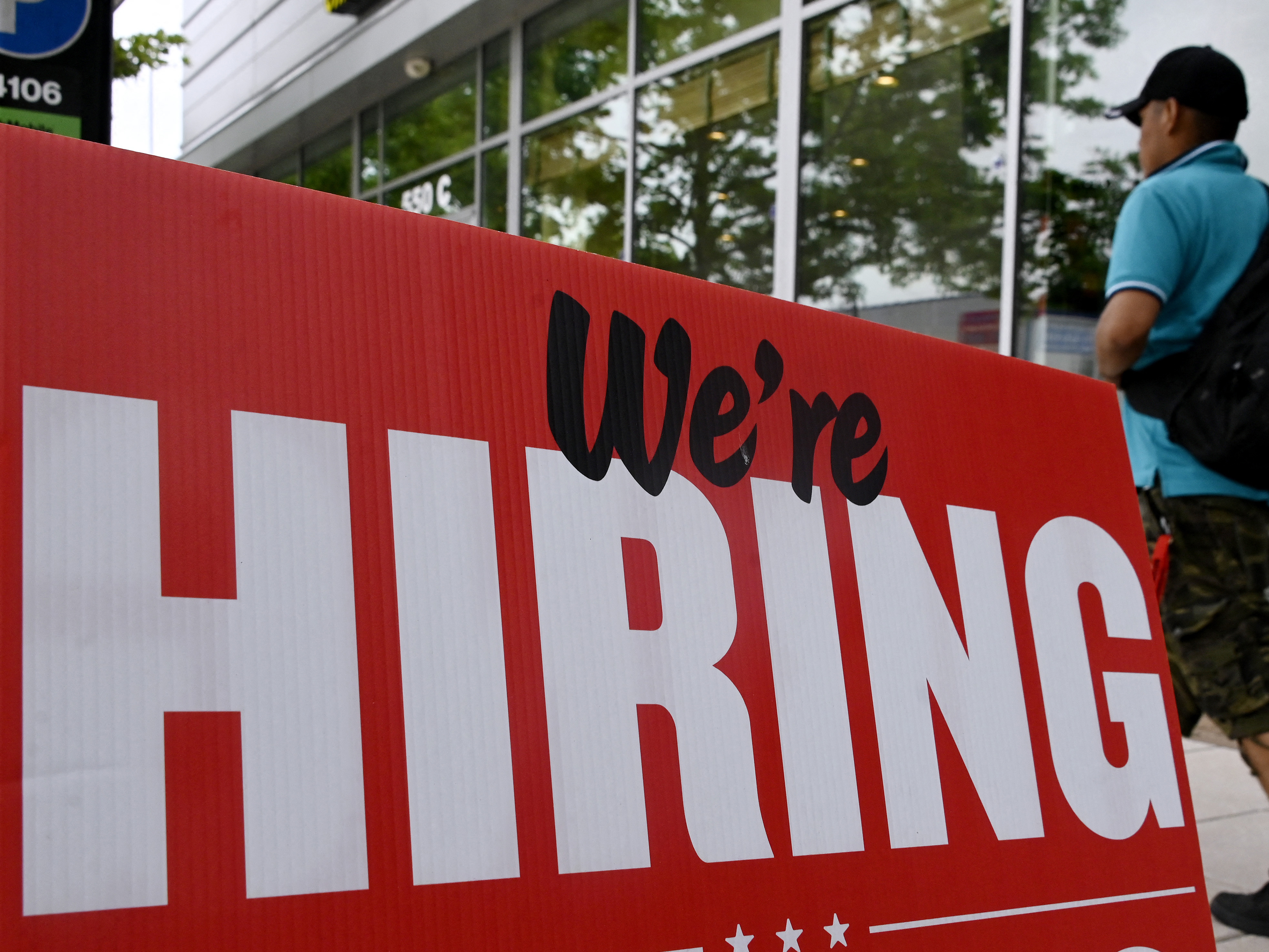 A man walks past a &quot;now hiring&quot; sign posted outside of a restaurant in Arlington, Va., on June 3. (AFP via Getty Images)