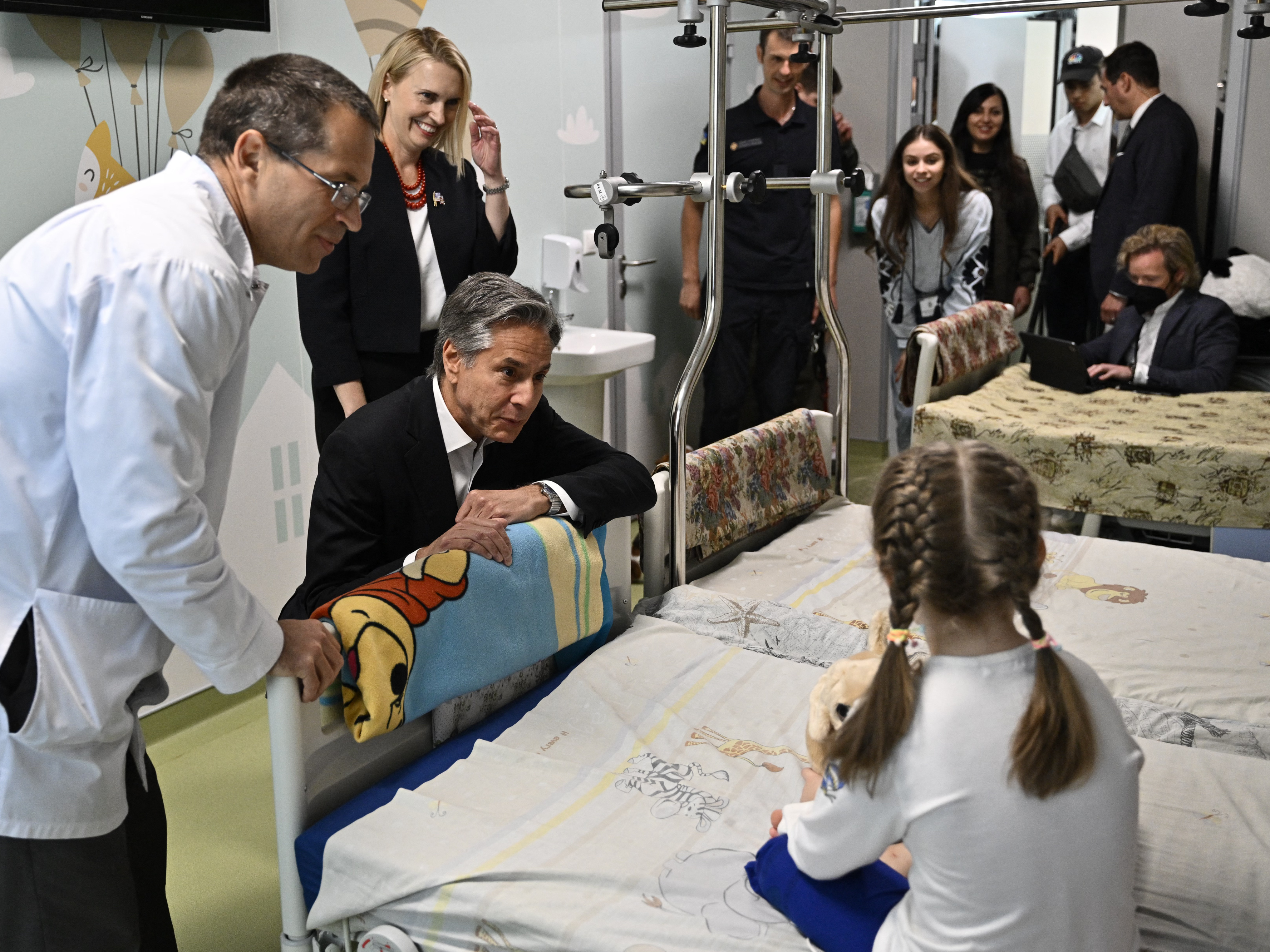 U.S. Secretary of State Antony Blinken talks with Marina, 6, from Ukraine's Kherson region, during his visit to a children's hospital in Kyiv on Thursday. (Pool/AFP via Getty Images)