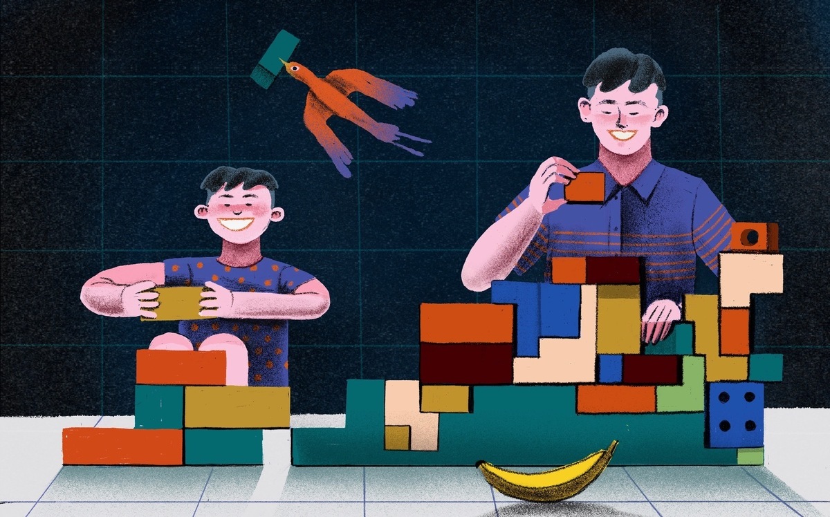 A young boy and teenage boy build blocks together.