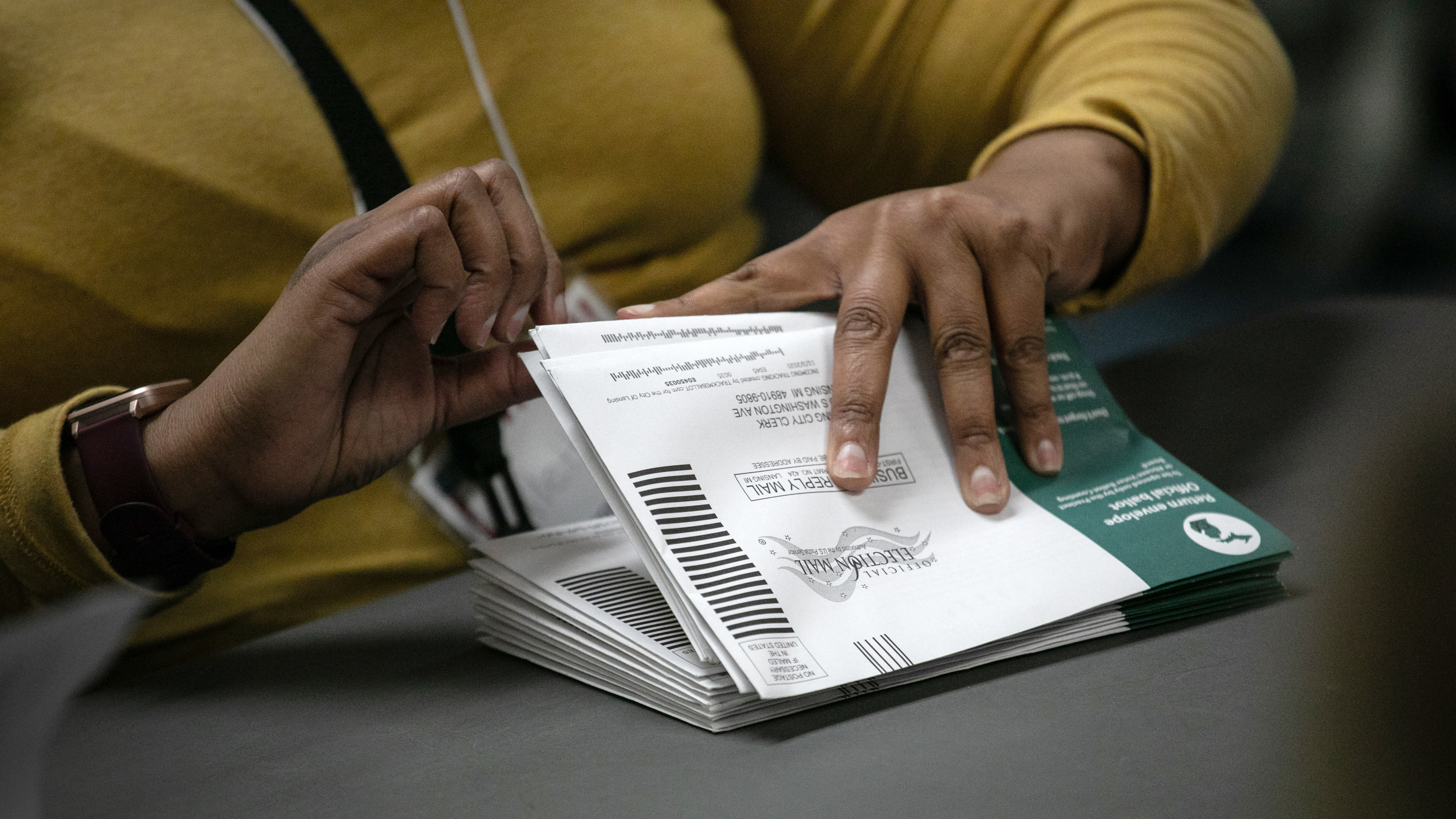 Election workers sort absentee ballots at the Lansing city clerk's office on Nov. 3, 2020, in Lansing, Mich. This fall, Michigan voters will weigh in on an expansive ballot question that would change the voting process. (Getty Images)