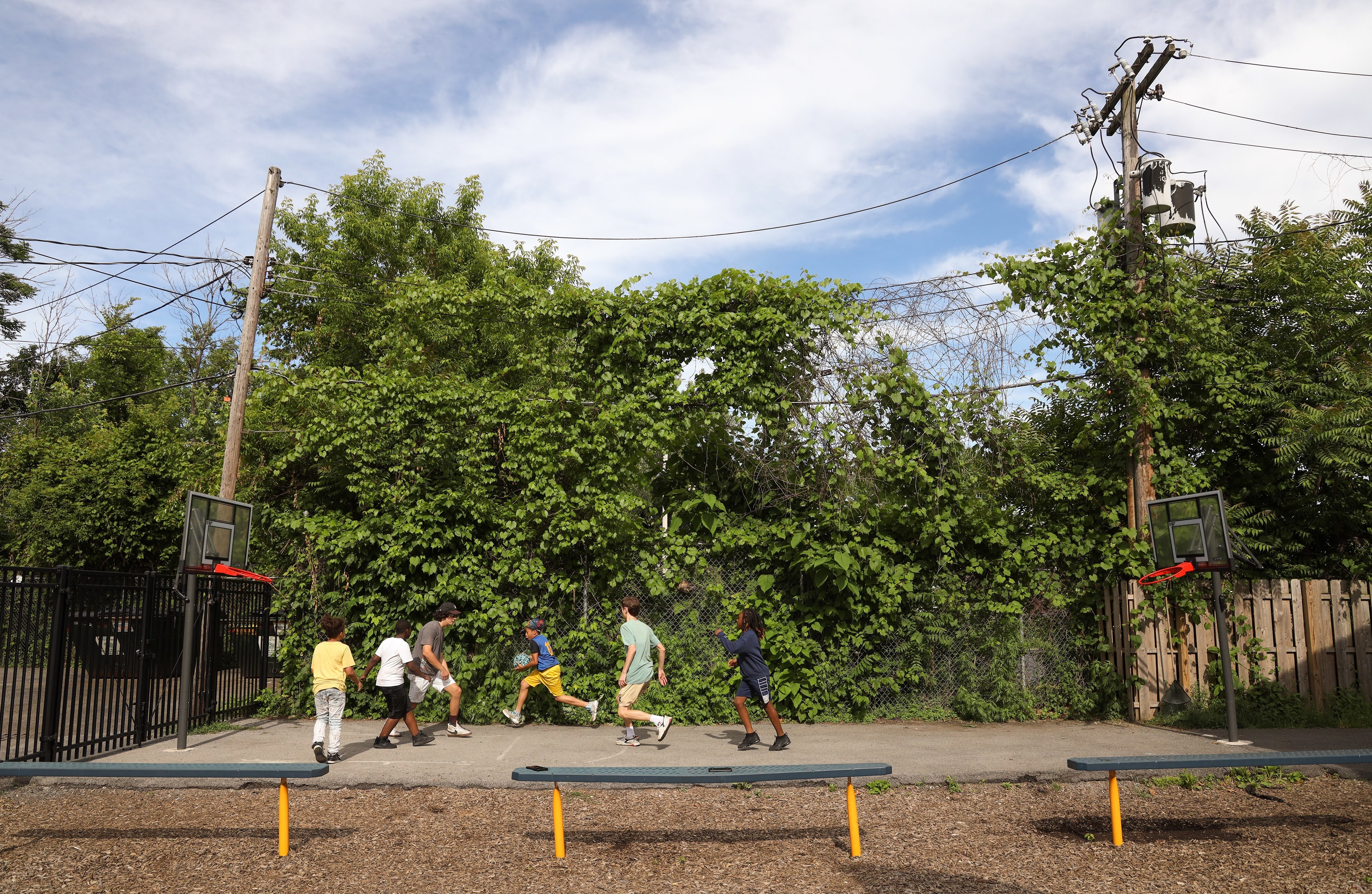 Volunteers from McQuaid Jesuit High School play basketball with the children of Cameron Community Ministries' after-school program. (WXXI News)