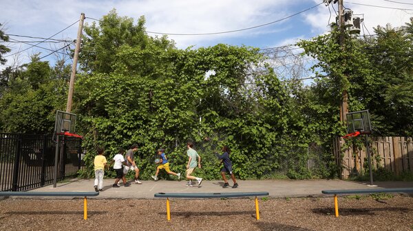 Volunteers from McQuaid Jesuit High School play basketball with the children of Cameron Community Ministries' after-school program.