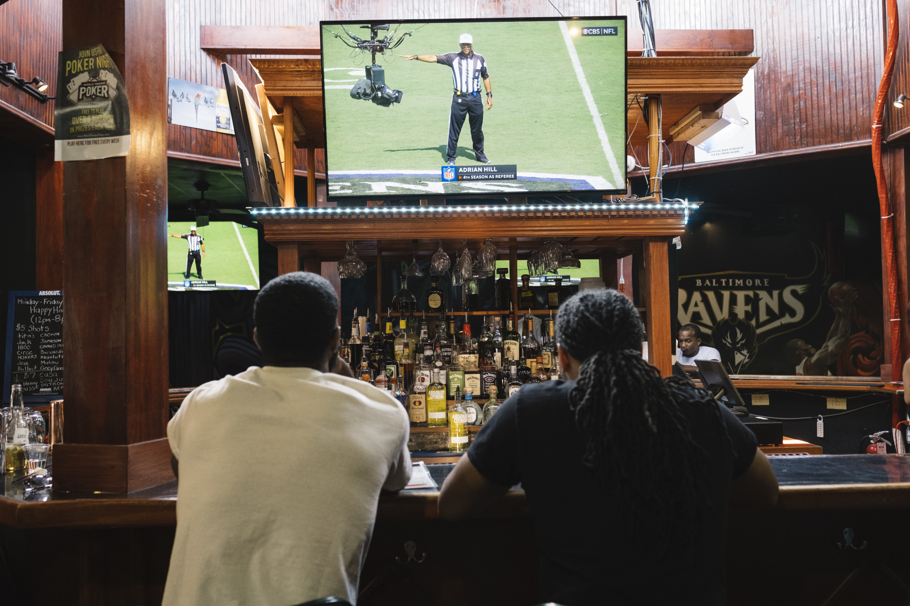 Football fans watch the Baltimore Ravens vs. Miami Dolphins at the Hamilton Sports Bar and Grill in Baltimore on Sept. 18. (Justin T. Gellerson for NPR)