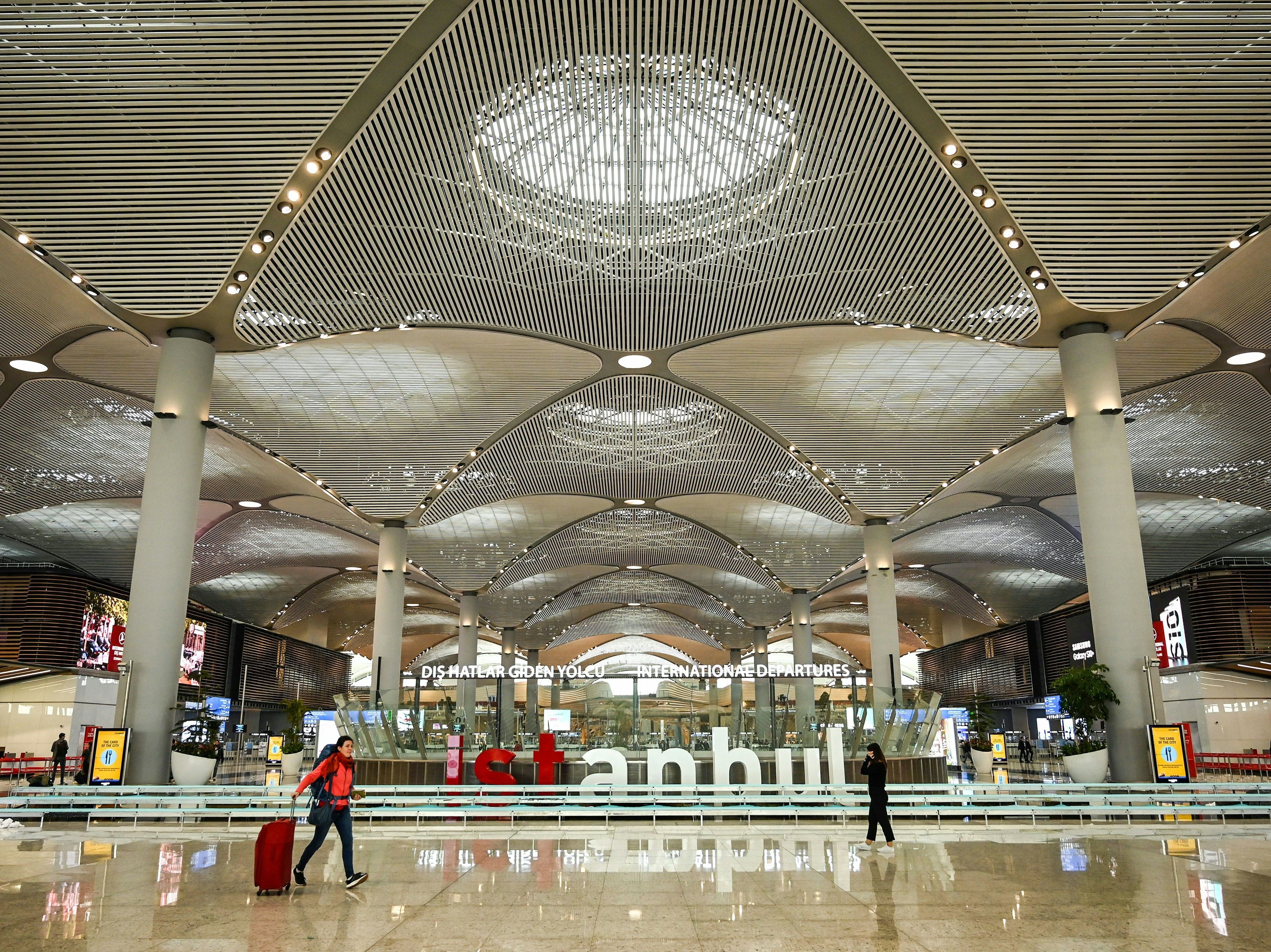 Passengers walk in the new hall of Istanbul Airport on the first day after moving from Ataturk International airport on April 6, 2019, in Istanbul. Many Russian men (not pictured) have been buying up tickets for Turkey since their government issued a draft to fight in Ukraine. (AFP via Getty Images)