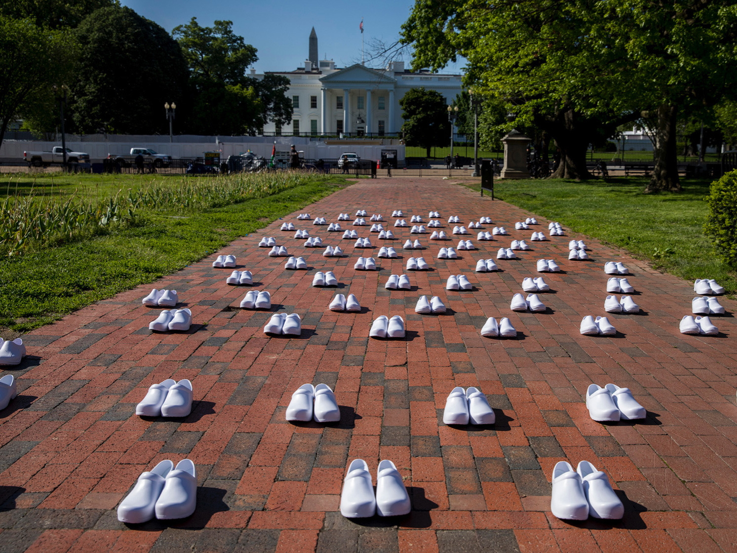 National Nurses United (NNU), staged a protest in front of the White House on Thursday, May 7, 2020. Area nurses stood among 88 pairs of white shoes, representing the number of nurses known to have died by that date of COVID-19, according to the union. (WAMU)