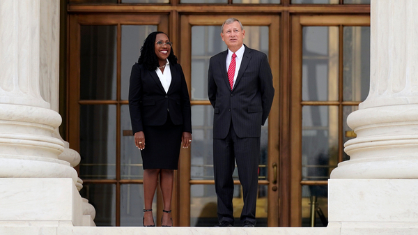 Supreme Court Associate Justice Ketanji Brown Jackson stands outside the Supreme Court with Chief Justice John Roberts, following her formal investiture ceremony at the Supreme Court in Washington on Sept. 30.