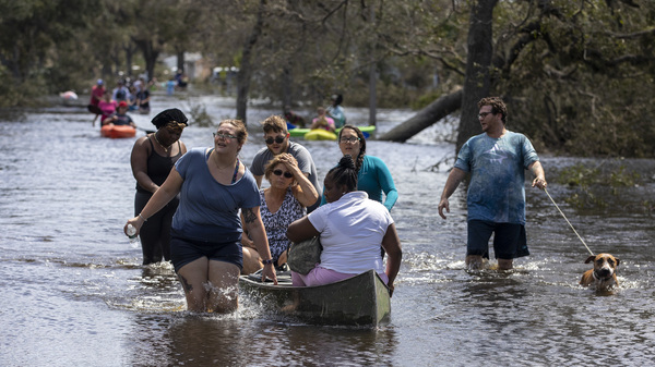 People leave the flooded community of Country Club Ridge in North Port, Fla., after hurricane Ian on Sept. 29, 2022.