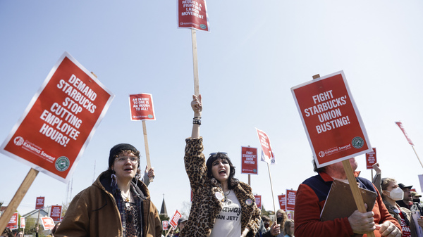 Marchers raise picket signs during a "Fight Starbucks