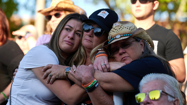 Lauren Reh, Alicia Mierke and Sue Ann Cornwell embrace during the Sunrise Remembrance ceremony at Clark County Government Center Amphitheater in Las Vegas on Oct. 1, 2022.