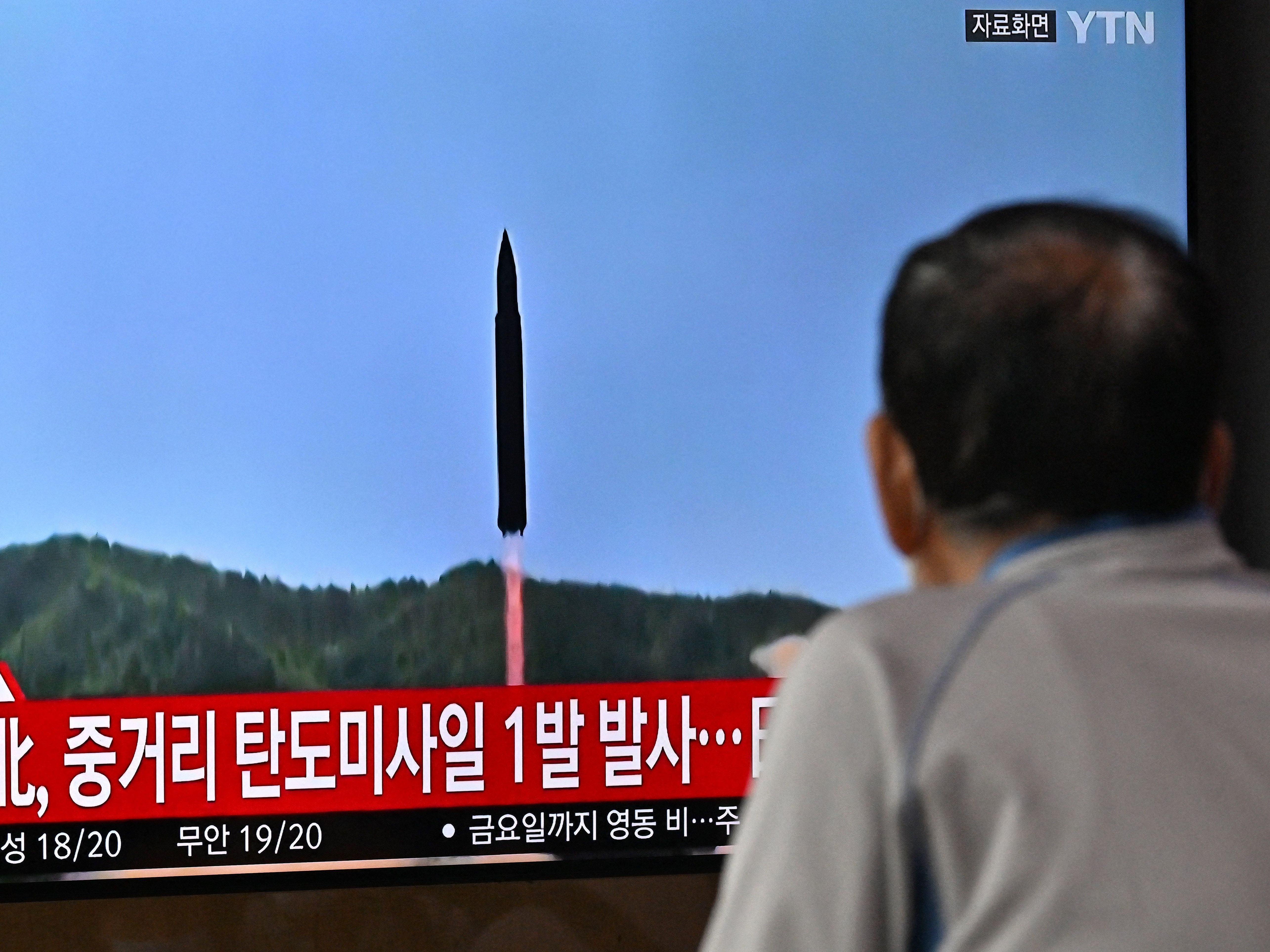 A man watches a television screen showing a news broadcast with file footage of a North Korean missile test, at a railway station in Seoul on October 4, 2022. (AFP via Getty Images)