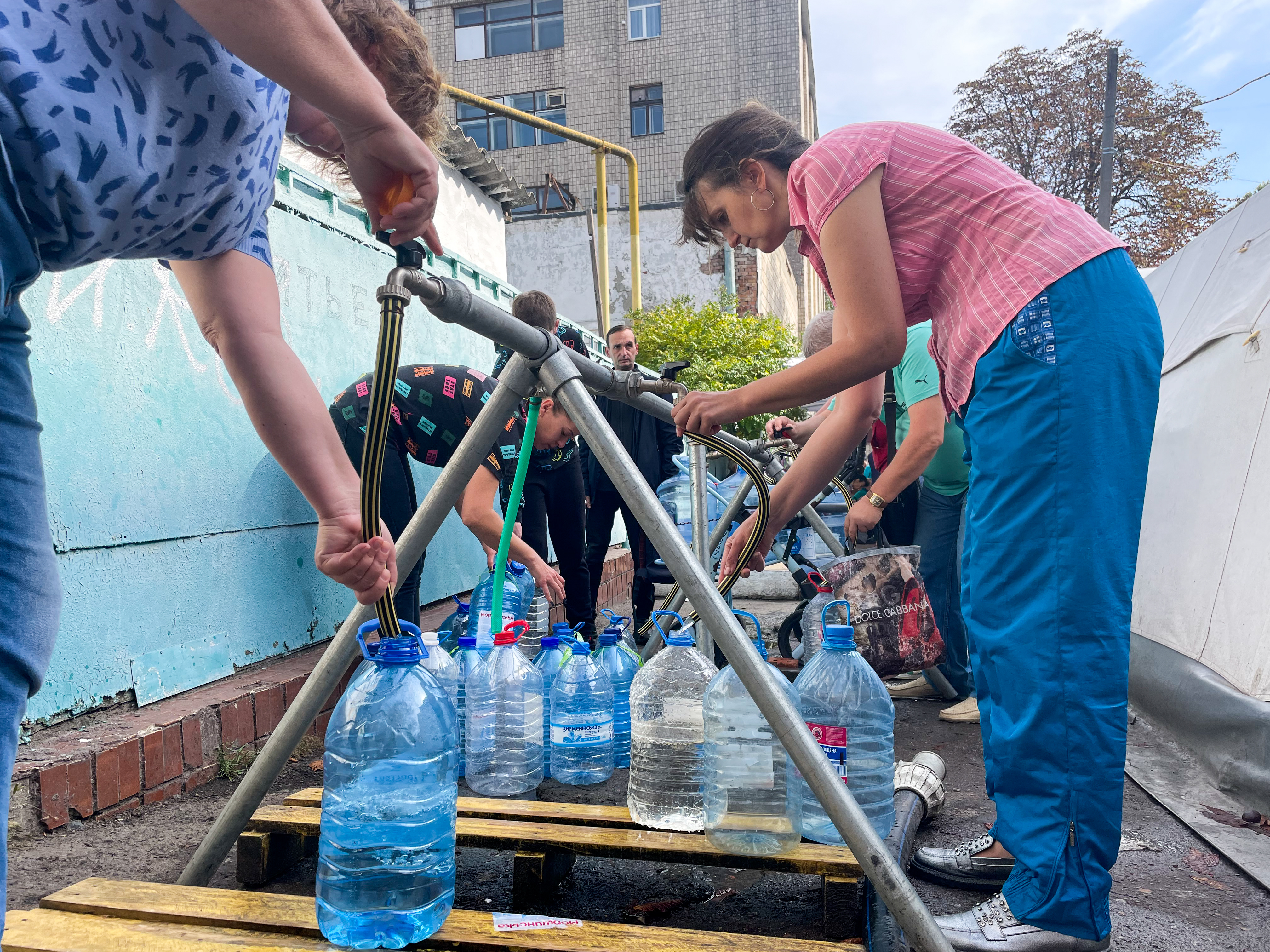 Residents of Mykolaiv collect clean water from a distribution station set up by the International Committee of the Red Cross on Oct. 1. (NPR)