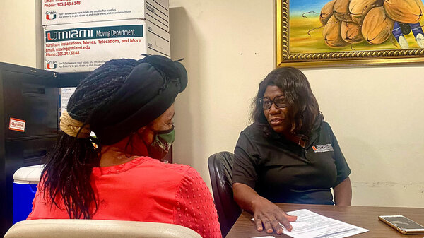 Nicole Daceus, who was recently tested for HPV through the University of Miami's Sylvester Comprehensive Cancer Center, speaks with Valentine Cesar (right), a community health worker. Having a culturally competent staff can be key to cutting through health care avoidance and fear, Cesar says.