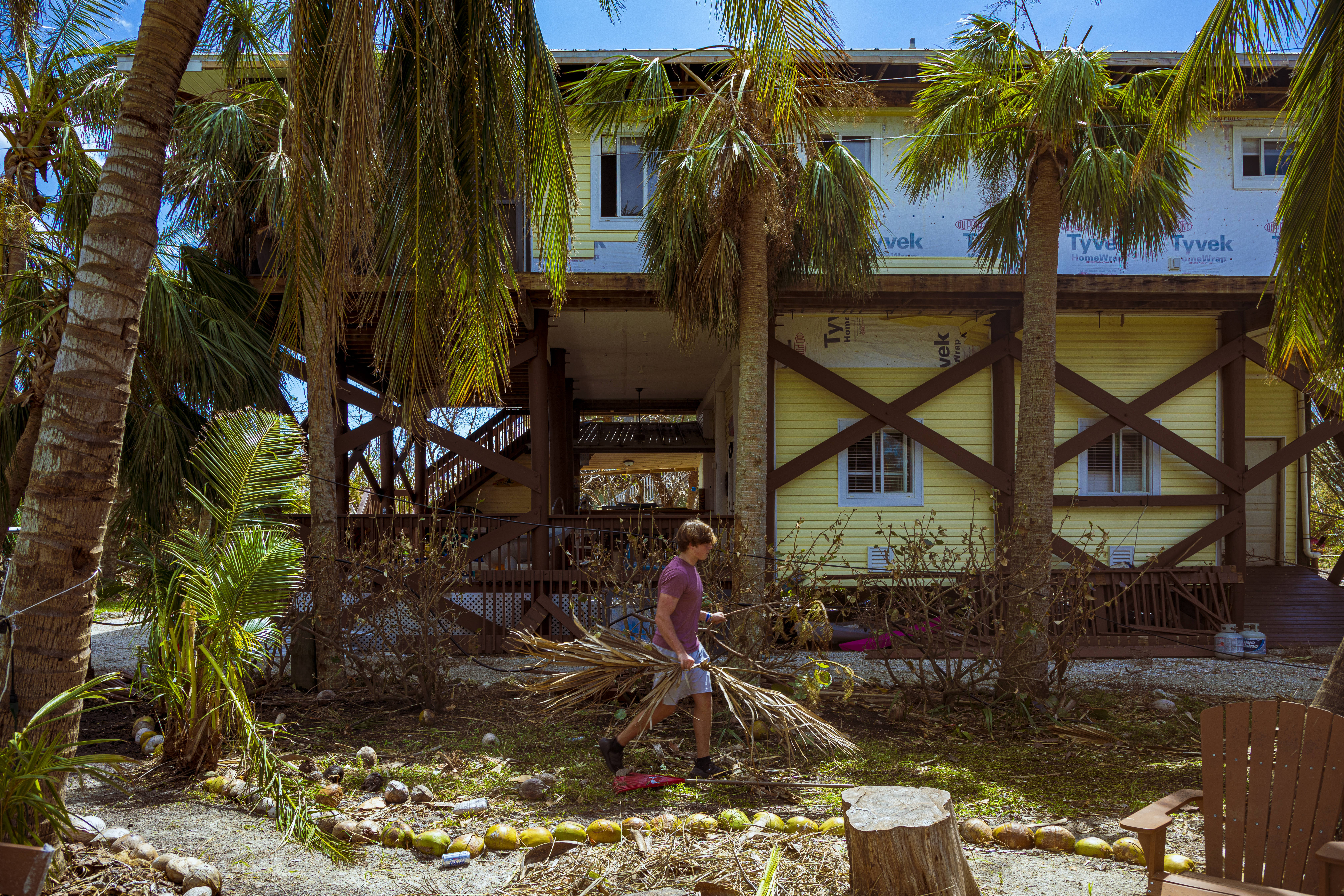 Jake Day cleans up part of his home that was damaged in Hurricane Ian on Little Gasparilla Island, Fla. (Saul Martinez for NPR)
