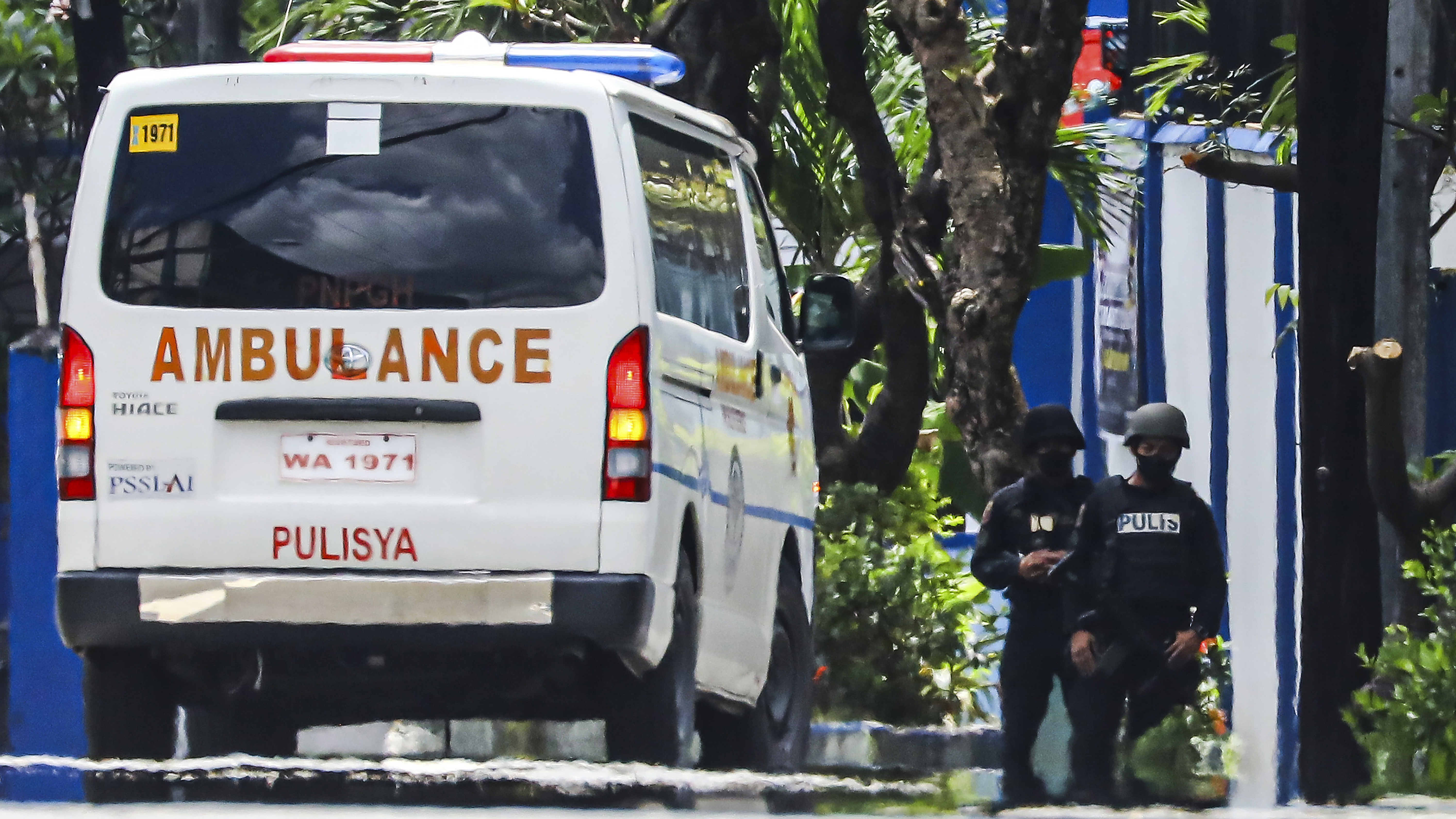Police keep watch as an ambulance is parked outside the PNP Custodial Compound in Camp Crame police headquarters, Metro Manila, Philippines on Sunday Oct. 9, 2022.