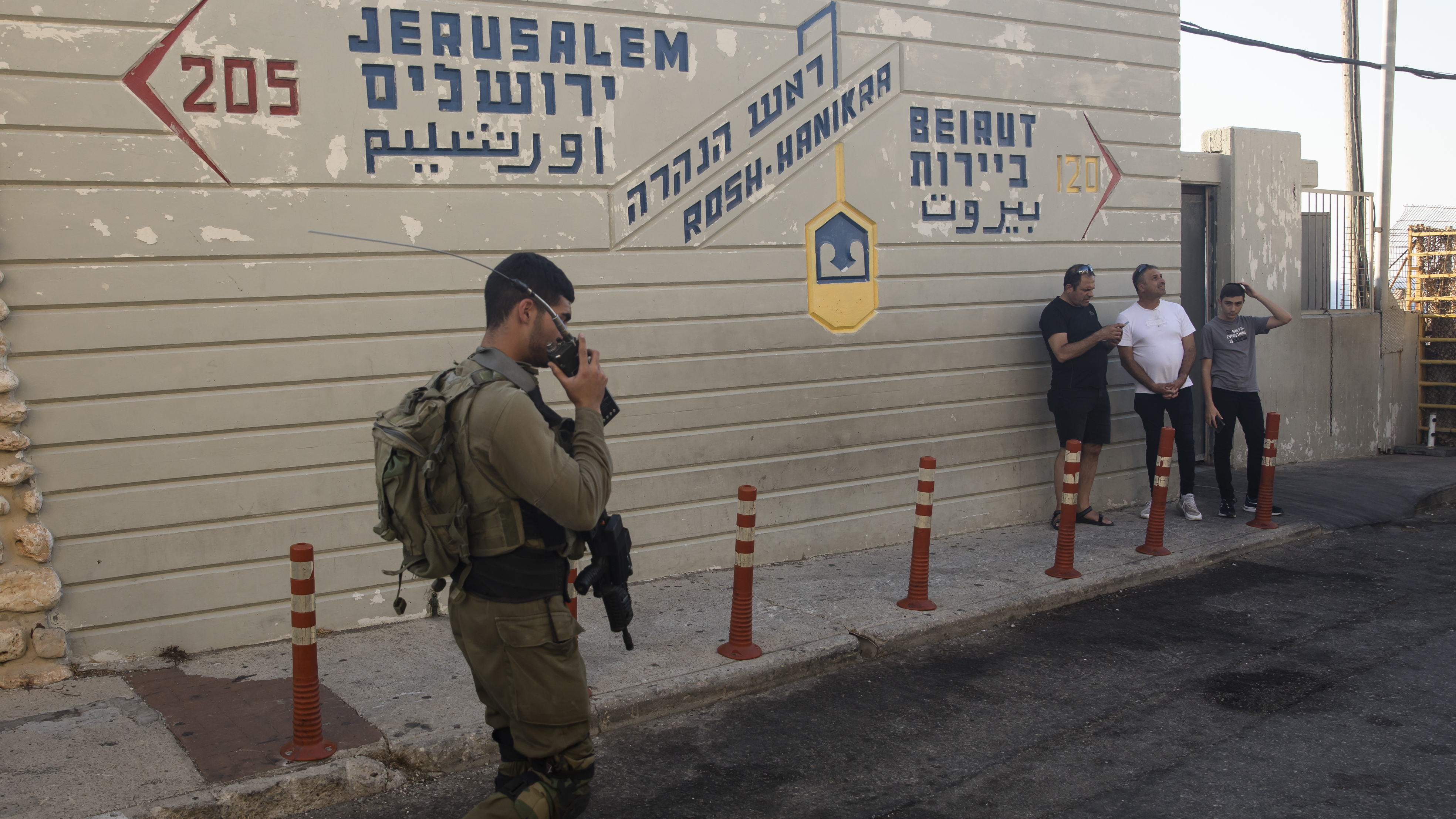 An Israeli soldier walks past a sign at a tourist site at the Israeli side of the border with Lebanon in Rosh Hanikra, Israel, on Tuesday.