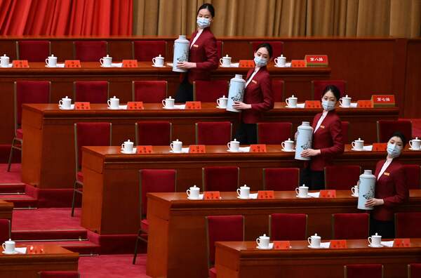 Attendants serve tea before the opening session of the congress.