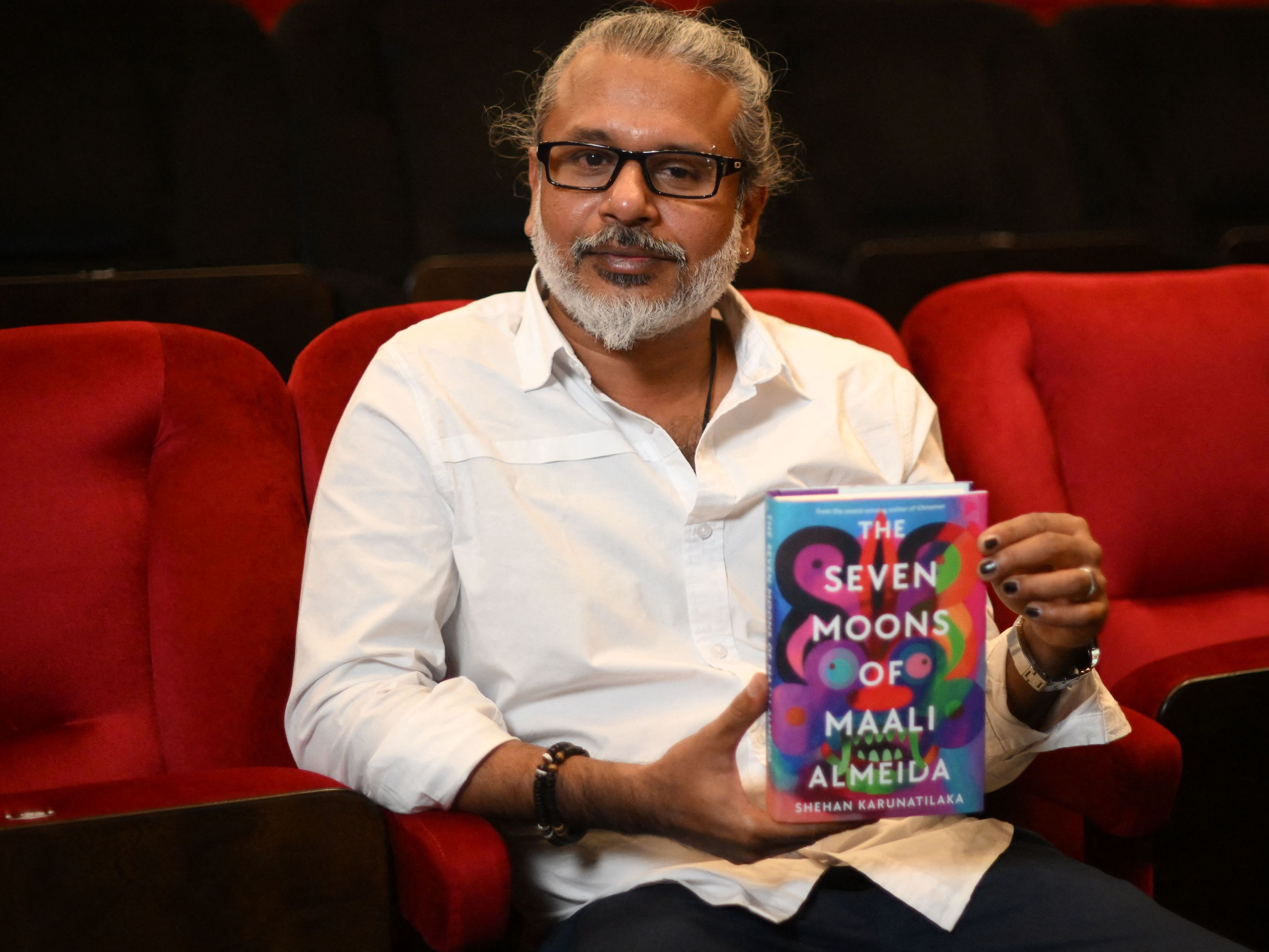Sri Lankan author Shehan Karunatilaka holds his book <em>The Seven Moons of Maali Almeida</em> at the Shaw Theatre in London on Oct. 14. On Monday, his novel won the 2022 Booker Prize. (AFP via Getty Images)