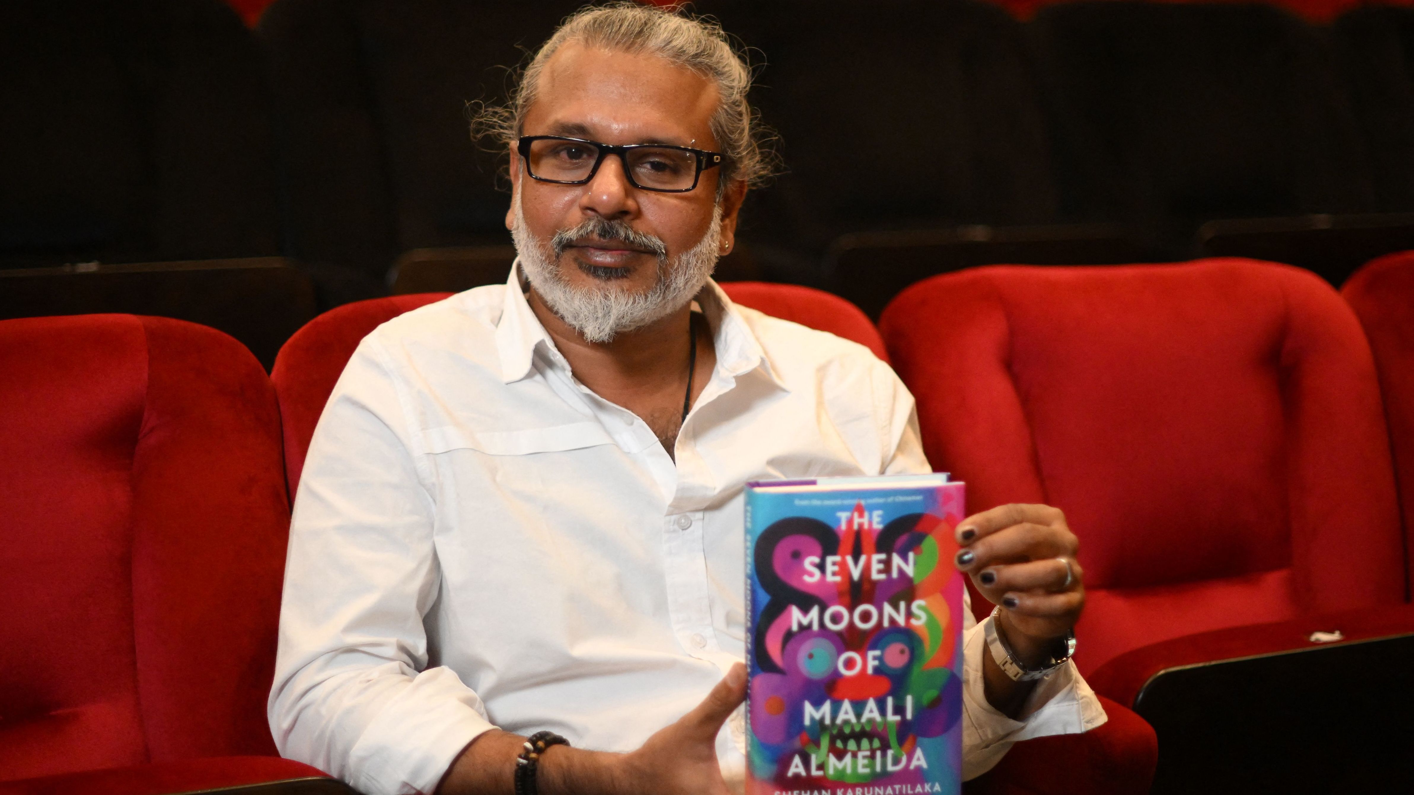 Sri Lankan author Shehan Karunatilaka holds his book The Seven Moons of Maali Almeida at the Shaw Theatre in London on Oct. 14. On Monday, his novel won the 2022 Booker Prize.