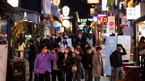People wearing protective face masks walk through the Itaewon district in Seoul, South Korea, on Friday, April 24, 2020.