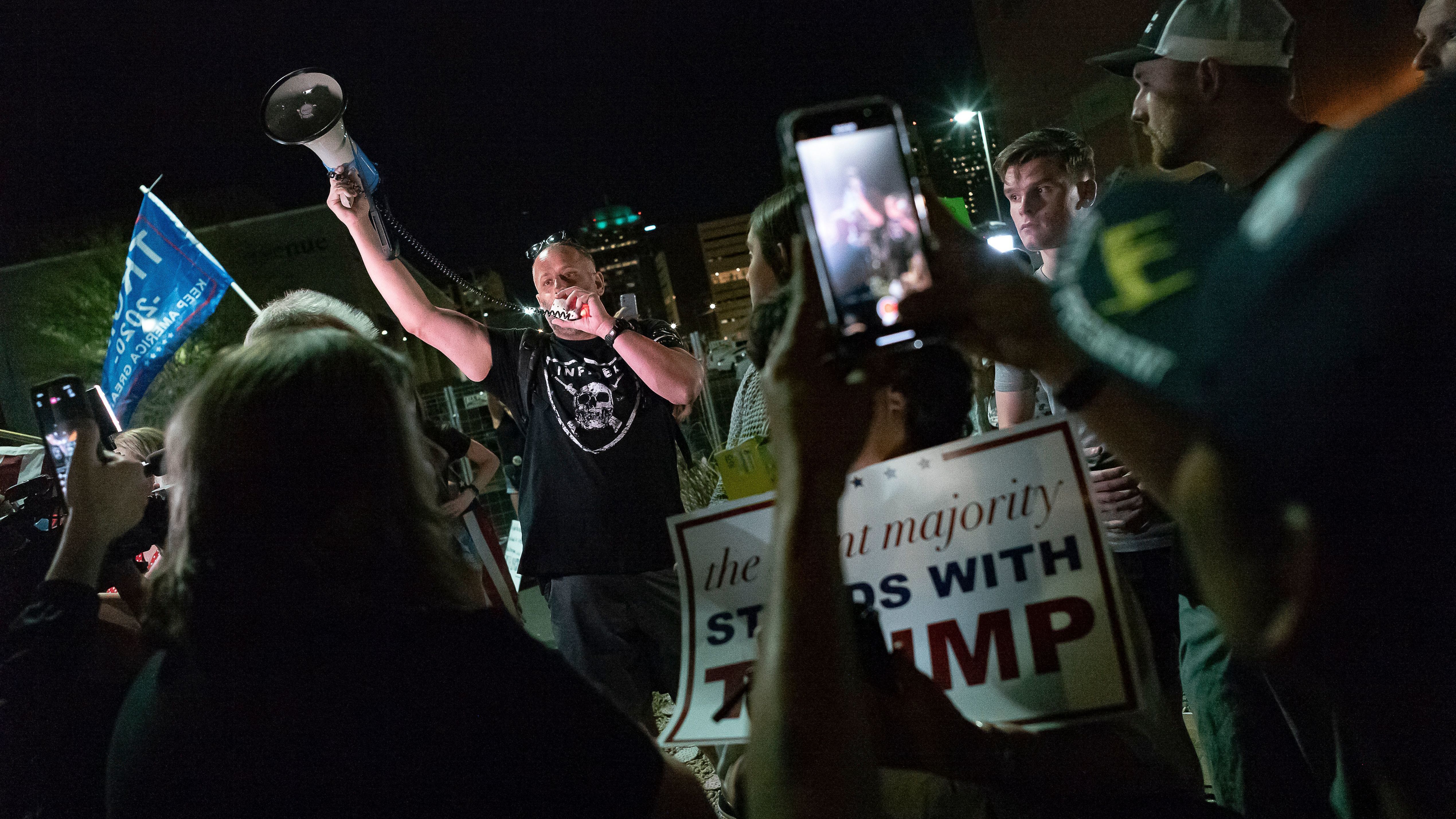 A man shouts into a bullhorn as Trump supporters gather in front of the Maricopa County Elections Department in Phoenix, where ballots were being counted following the 2020 presidential election. Federal officials have warned about violence erupting after this year's election, with experts particularly concerned about the period after Nov. 8. (AFP via Getty Images)