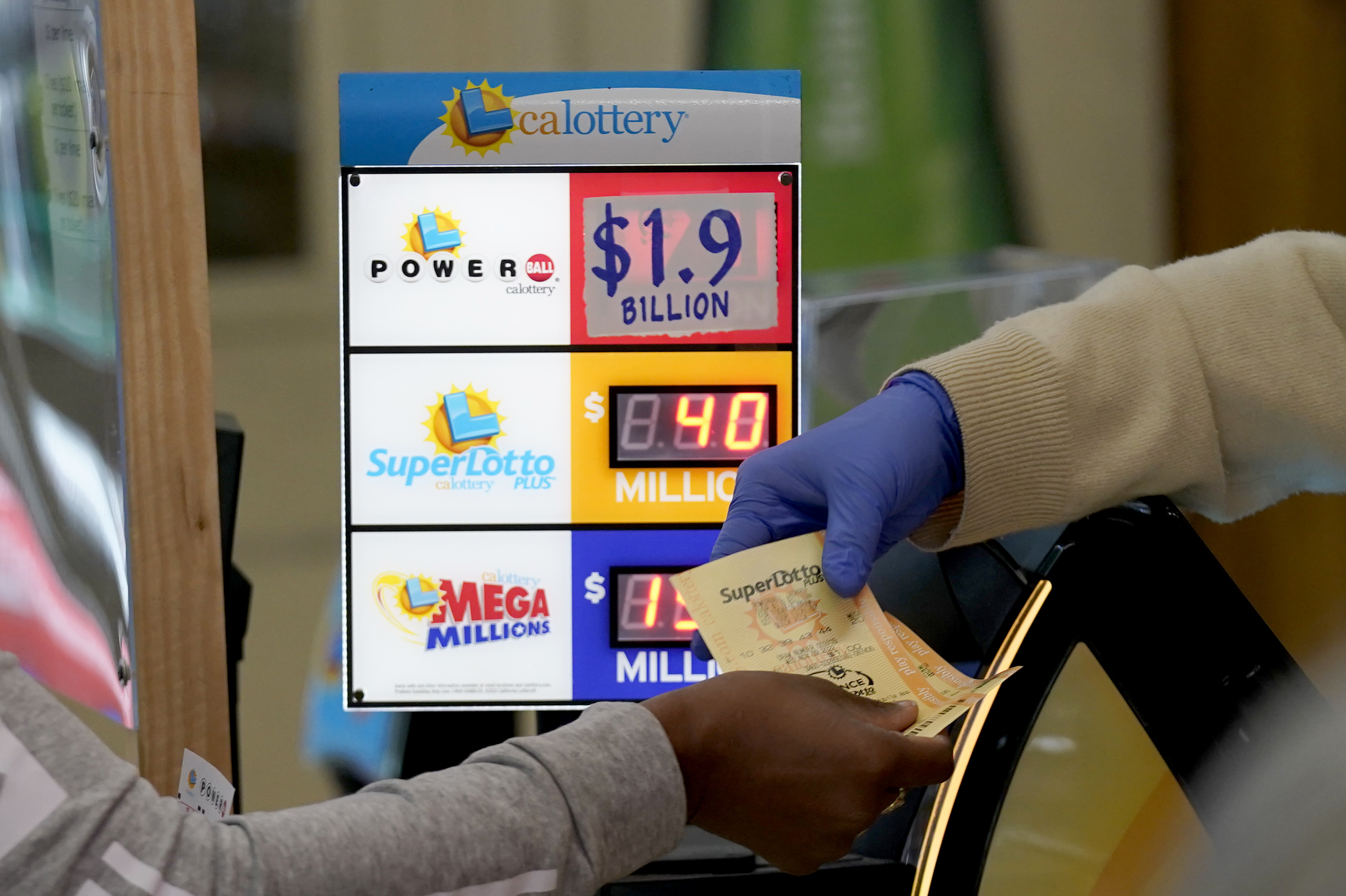 A customer is handed Powerball tickets purchased at Lichine's Liquor & Deli in Sacramento, Calif., Monday, Nov. 7, 2022. Monday night's drawing is estimated to be a record $1.9 billion.
