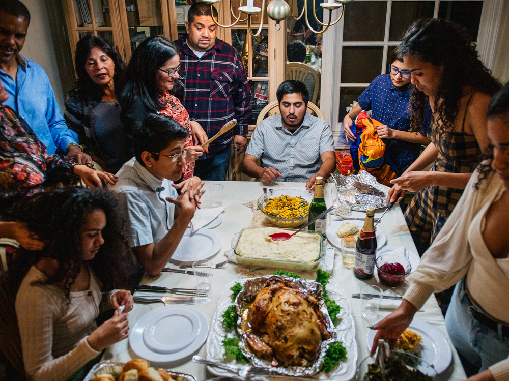 The Broughton family prepares for their dinner prayers during a gathering on November 26, 2020 in Los Angeles, California. Prices for Thanksgiving staples like turkey are on the rise this year, thanks to inflation. (Getty Images)