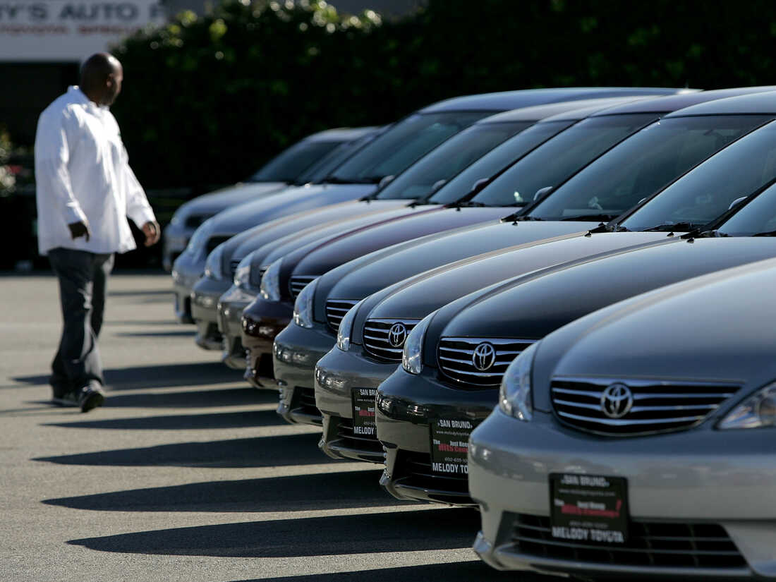 A man inspects new Toyota cars on display at Melody Toyota in San Bruno, California.