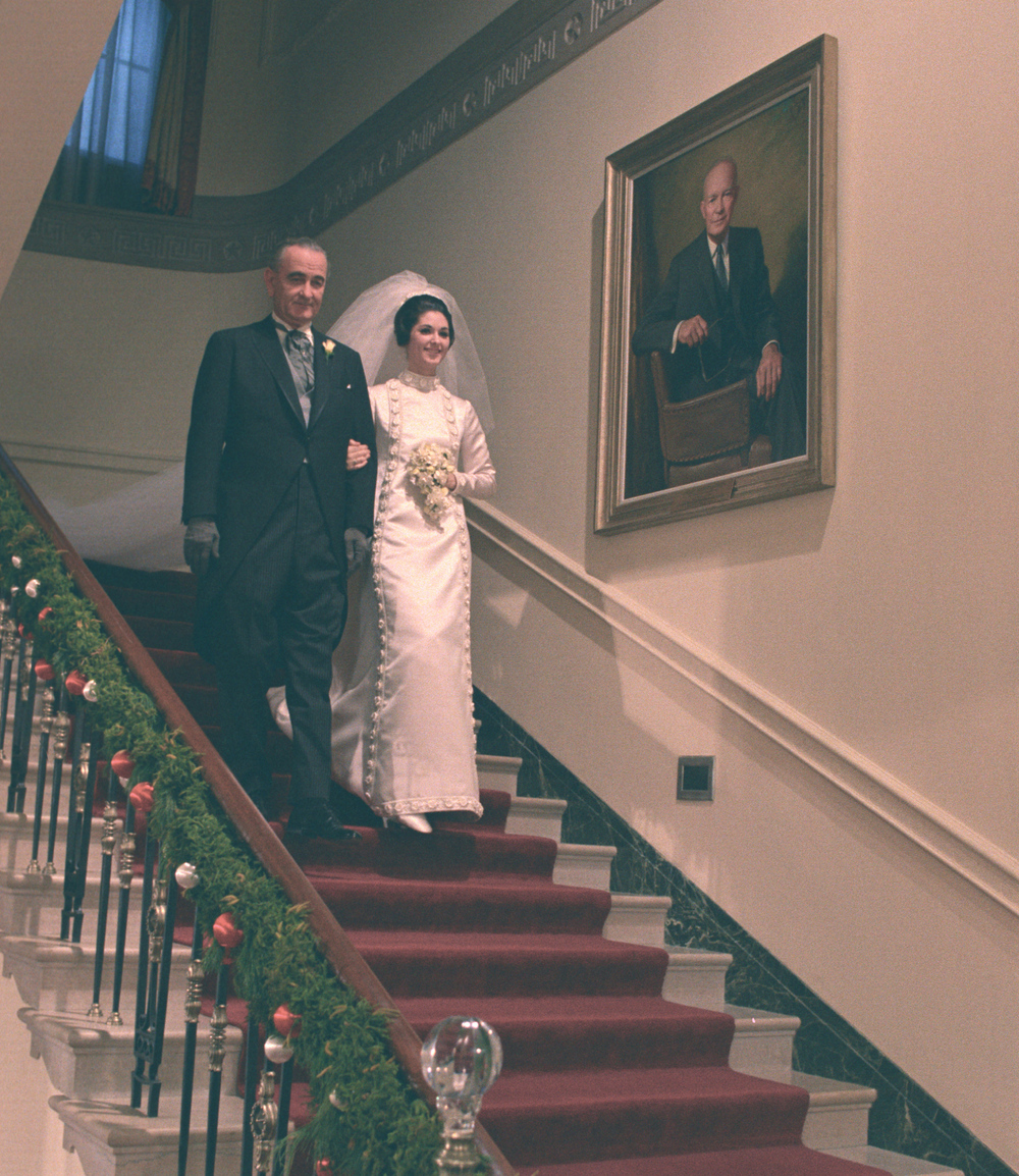 President Johnson escorted his daughter Lynda Bird Johnson down the Grand Staircase for her wedding ceremony.