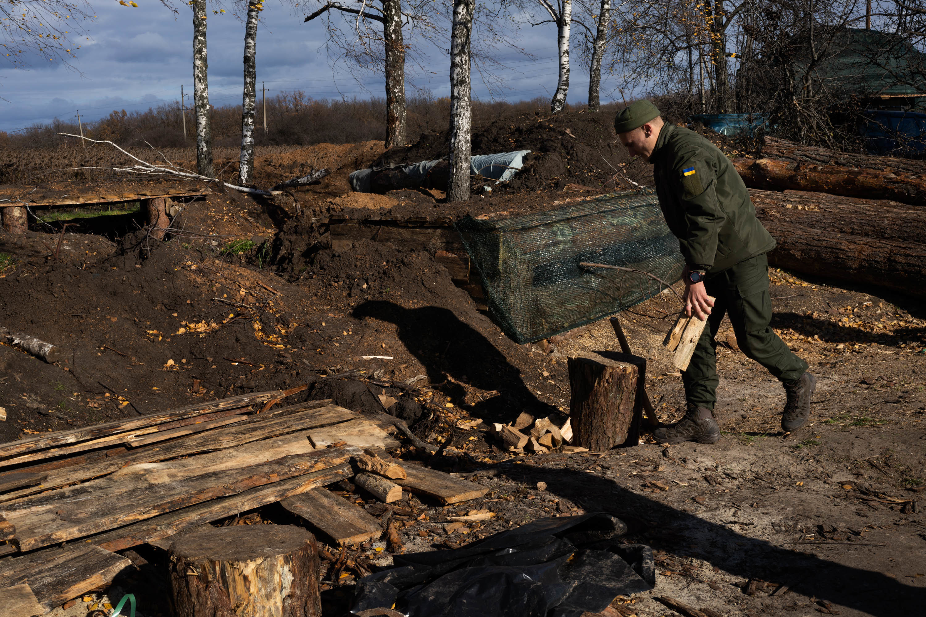 With winter approaching, Ukraine prepares to fight on frozen ground 9 A soldier moves wood to chop for heating in the trenches in Kharkiv region.
