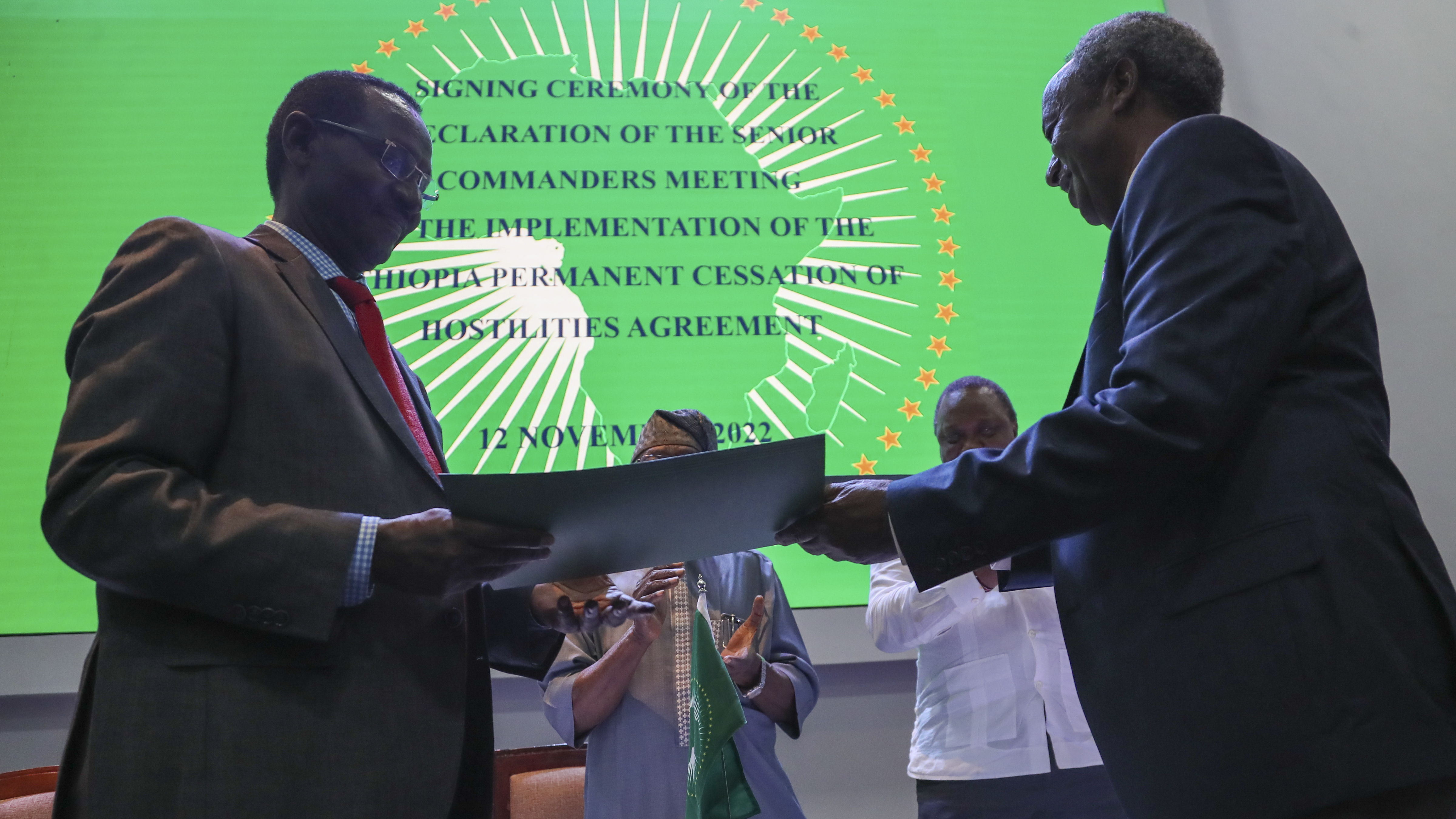 Chief of Staff of Ethiopian Armed Forces Field Marshall Birhanu Jula, left, and Head of the Tigray Forces Lt. Gen. Tadesse Werede, right, exchange signed copies of an agreement, at Ethiopian peace talks in Nairobi, Kenya, on Saturday.