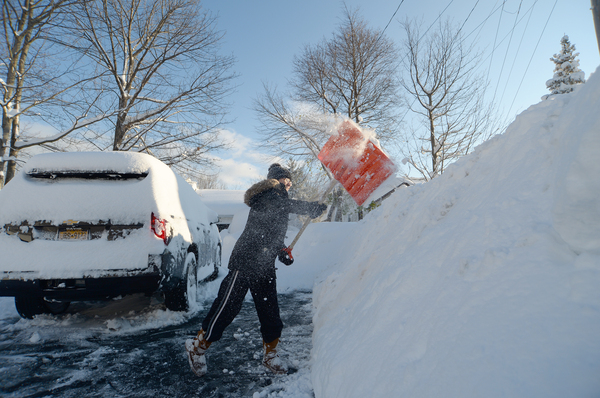 Heather Ahmed digs out after an intense lake-effect snowstorm impacted the Buffalo, New York, area on Saturday.