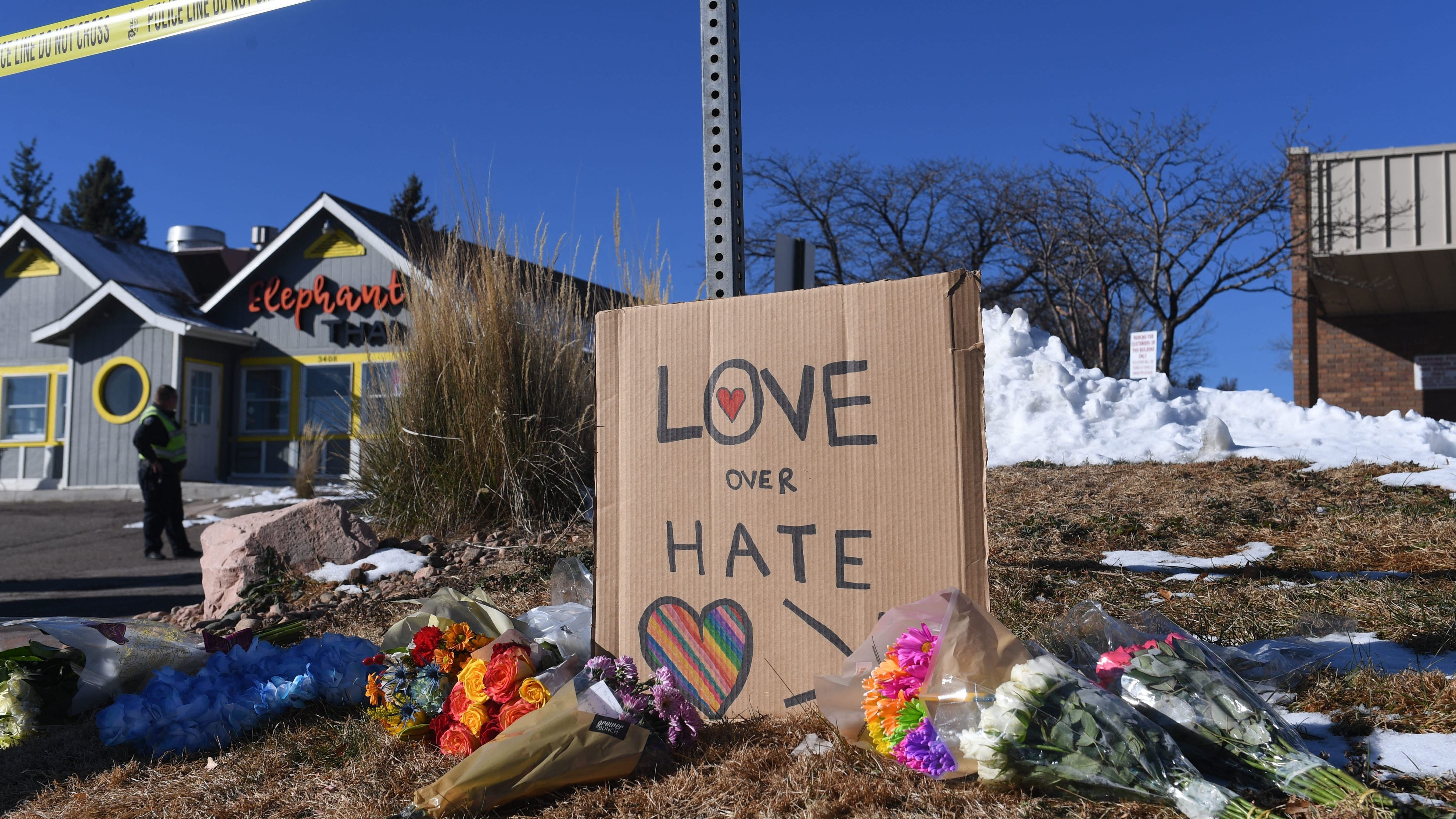 Bouquets of flowers and a sign reading "Love Over Hate" are left near Club Q, the LGBTQ nightclub in Colorado Springs, Colorado, after a shooting on Sunday.