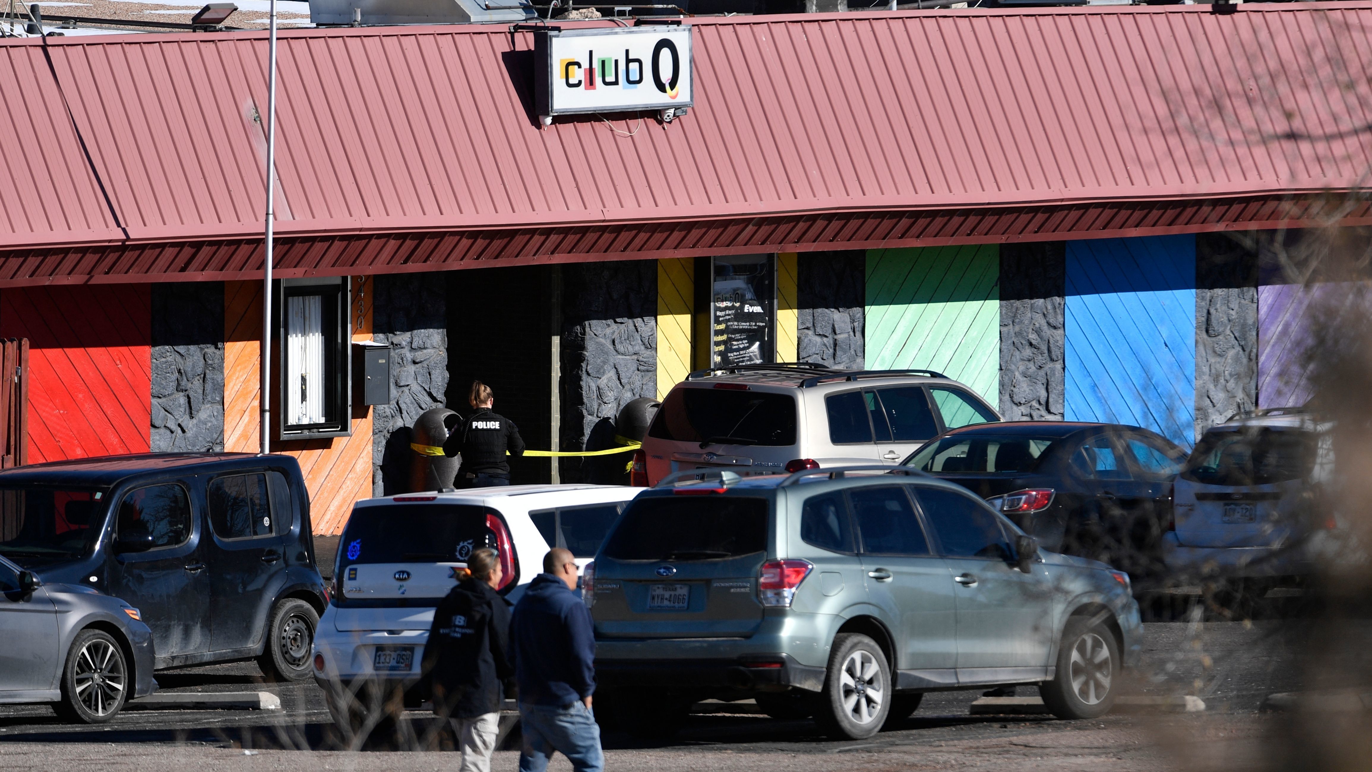 Law enforcement officers walk through the parking lot of Club Q, an LGBTQ nightclub, in Colorado Springs, Colo., on Sunday.