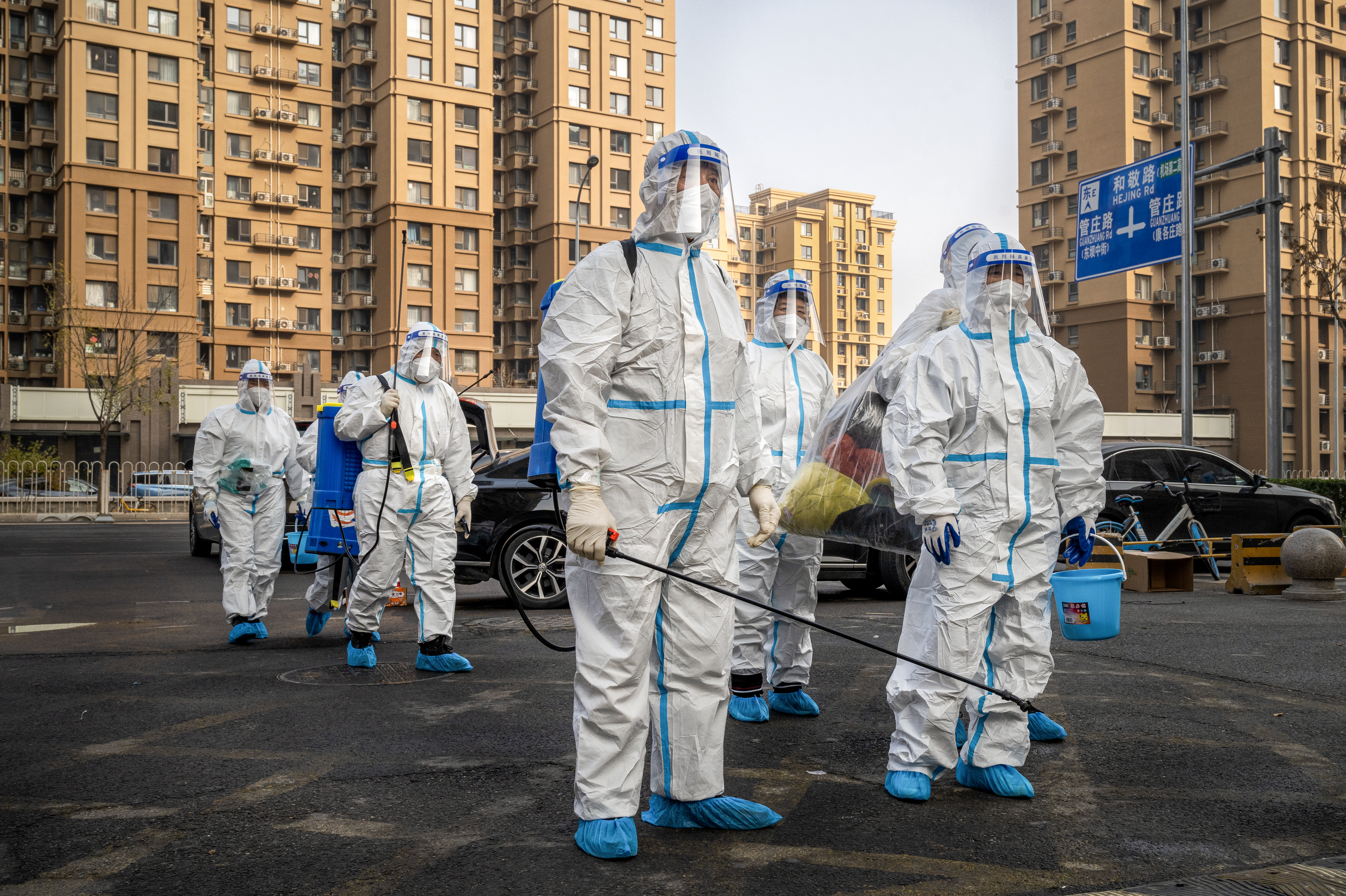 Workers wear protective gear in a Beijing neighborhood placed under lockdown in November. China had raised hopes by slightly relaxing its zero-COVID policy, but cities have been contending with a surge in cases. (Bloomberg via Getty Images)