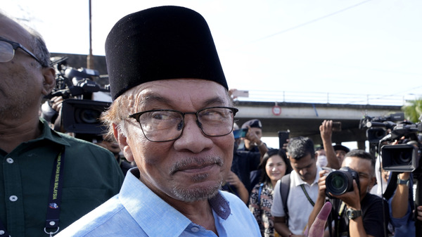 Opposition leader Anwar Ibrahim shows his inked finger to the media after voting at a polling station in Seberang Perai, Penang state, Malaysia on Nov. 19, 2022.
