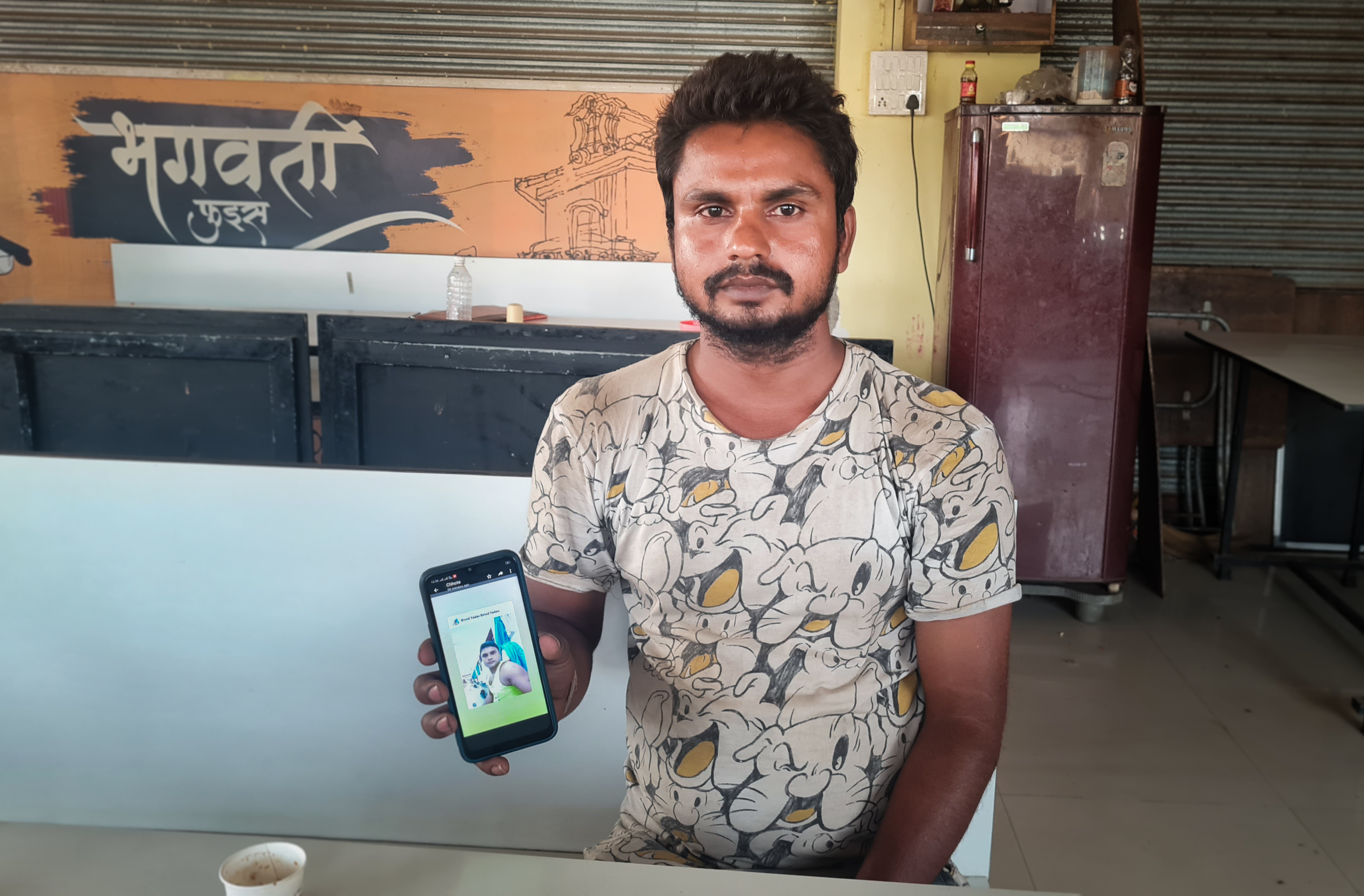 Ashwini Kumar, 24, shows a photo on his phone of his brother Vinod, who died in October 2020 in Qatar, where he was one of the many migrant workers building World Cup stadiums. His family has heard conflicting stories about the cause of death — from a workplace accident to suicide. (Lauren Frayer/NPR)