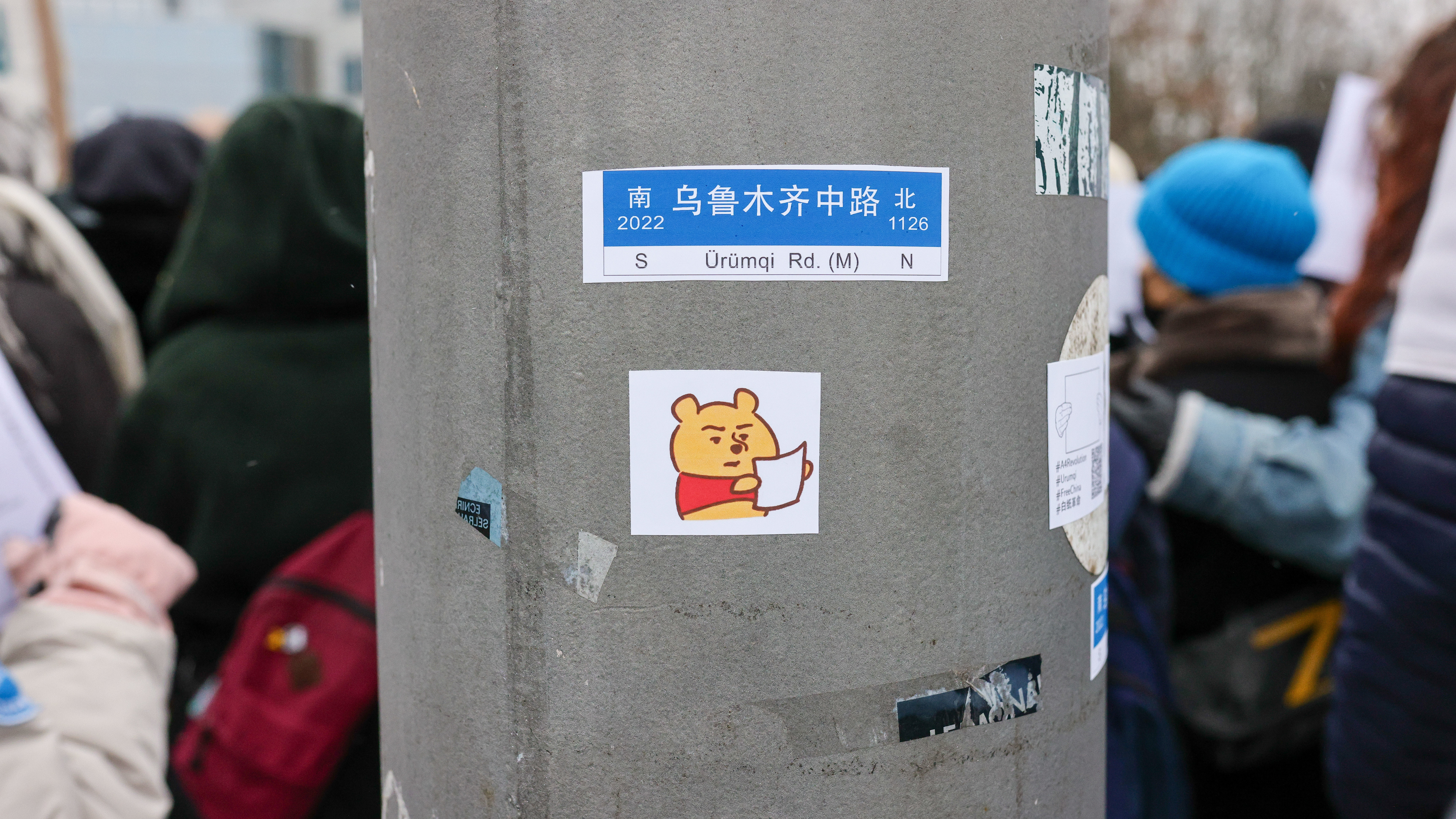 A sticker depicting Winnie the Pooh holding a blank paper was placed on a post as demonstrators protested in front of the Chinese Embassy in solidarity with protesters in China on Saturday in Berlin, Germany.