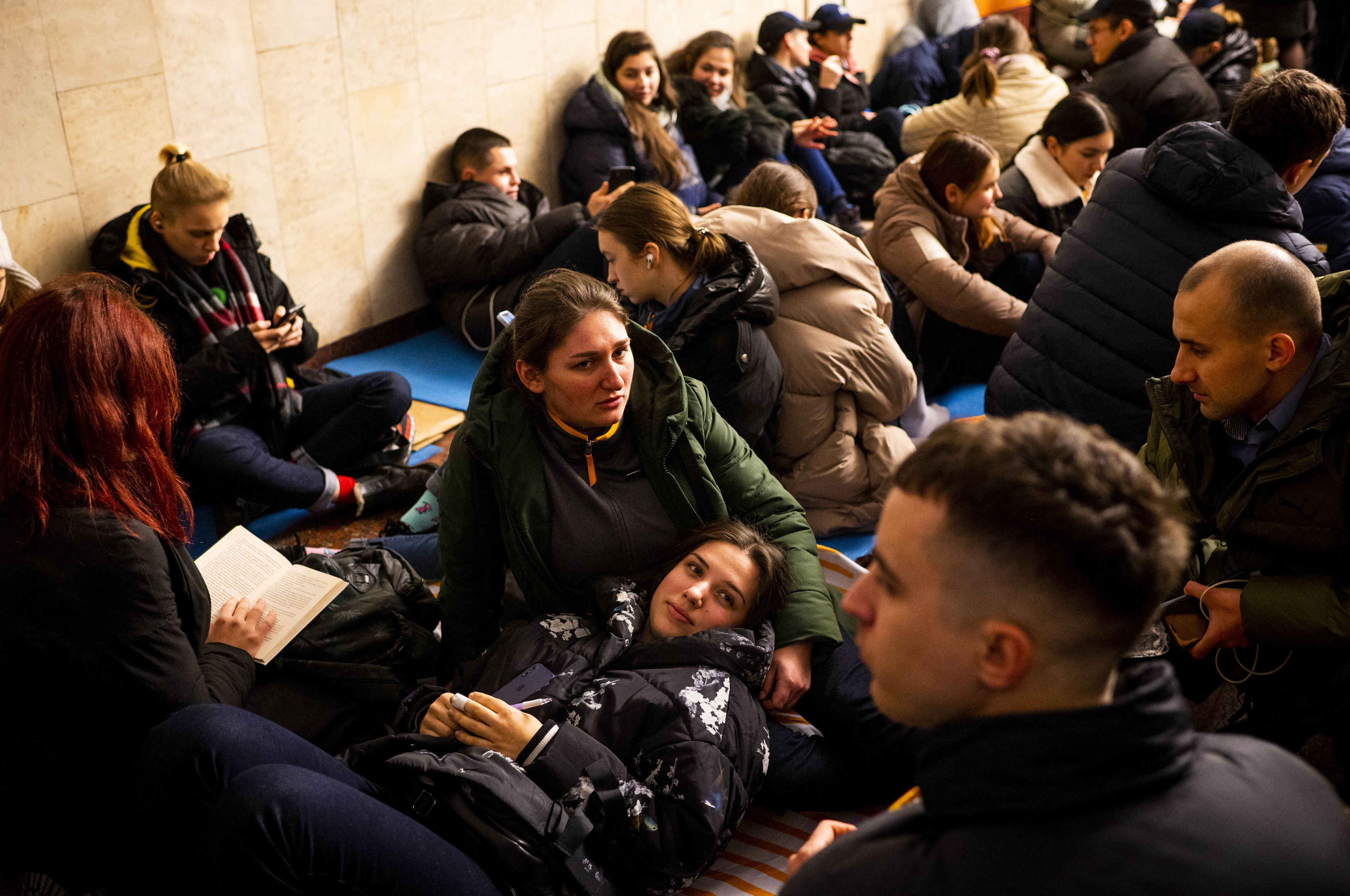 Svitlana (center) and Anastasiya (bottom) take shelter with their McDonald's coworkers in Lva Tolstoho Metro during an air alert in Kyiv on Monday. Russia renewed its missile attacks across Ukraine on Monday. (Pete Kiehart for NPR)