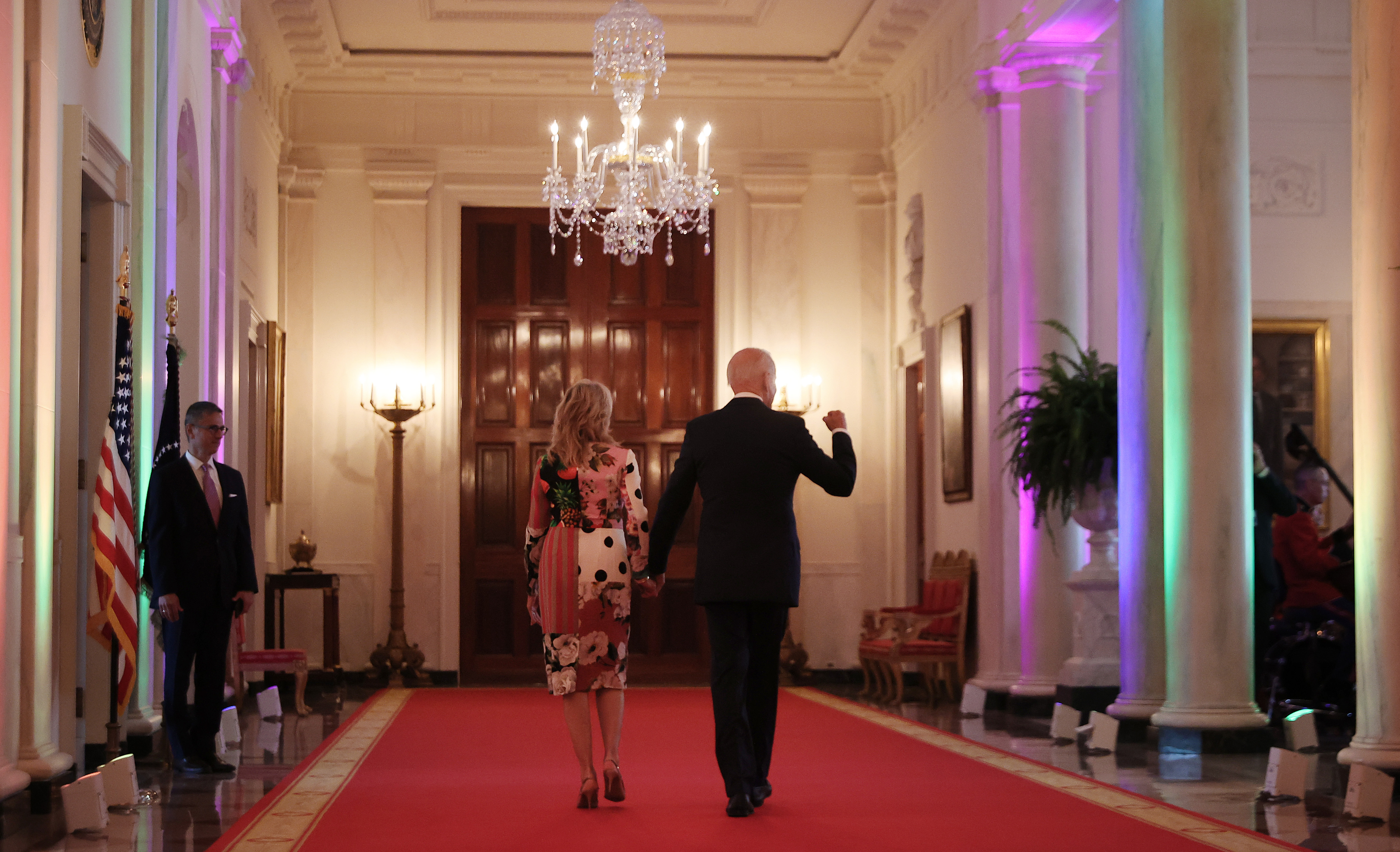 President Biden and first lady Jill Biden walk through the Cross Hall of the White House lit with rainbow colors following an event commemorating LGBTQ+ Pride Month in the East Room last year. (Getty Images)