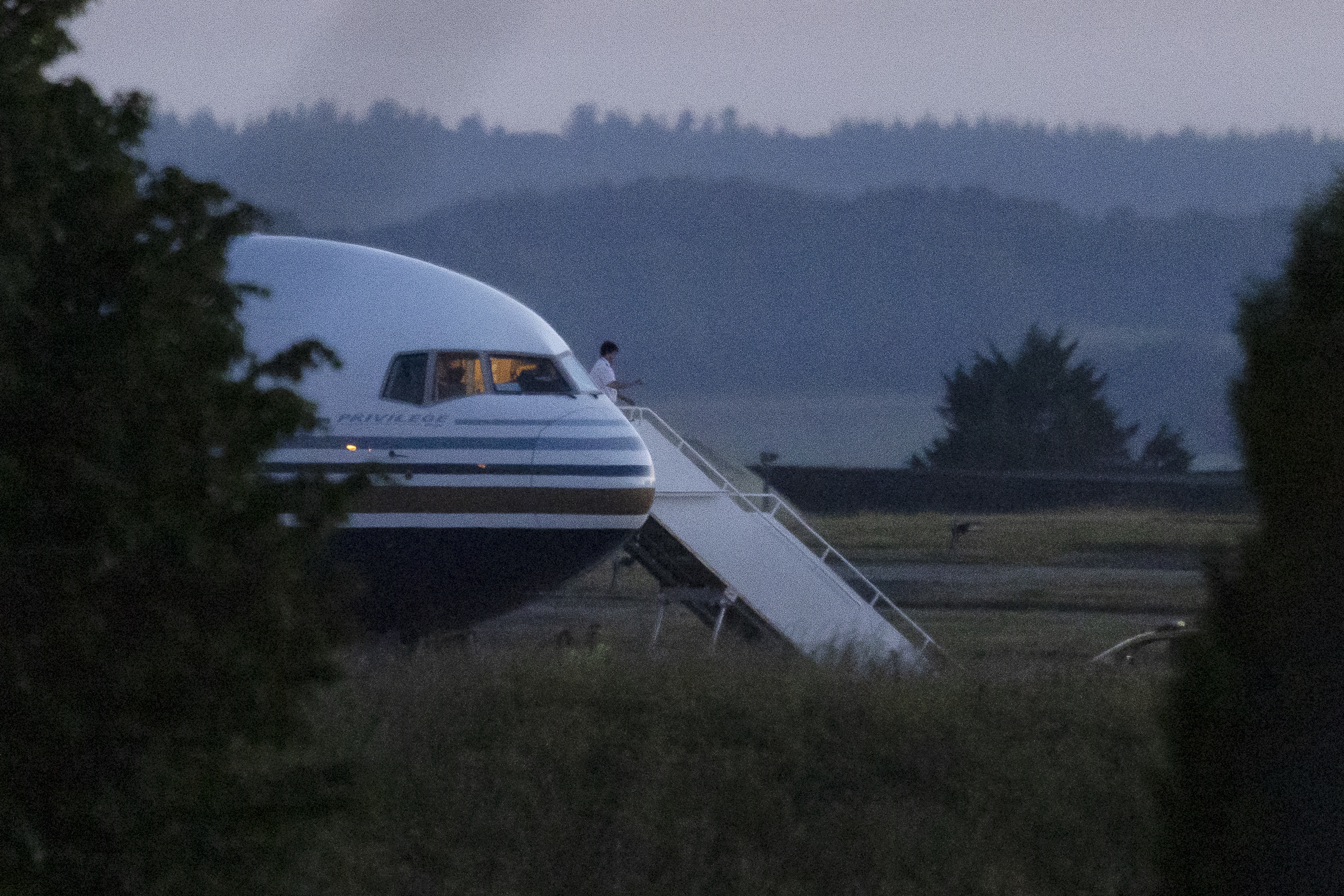 A pilot gestures from the grounded EC-LZO Boeing 767 flight, initially meant to deport Rwandan asylum-seekers, at Boscombe Down Air Base in Boscombe Down, England, on June 14. The flight taking asylum-seekers from the U.K. to Rwanda was grounded at the last minute, after the intervention of the European Court of Human Rights. (Dan Kitwood/Getty Images)