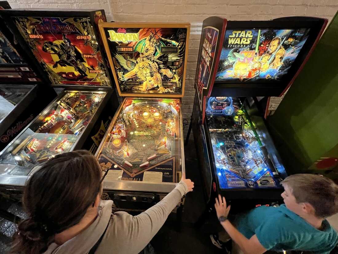 Amanda Hembree and her son, Charlie, 9, play pinball recently at Solid State Pinball Supply. The arcade has Kansas City's largest public collection of pinball machines.