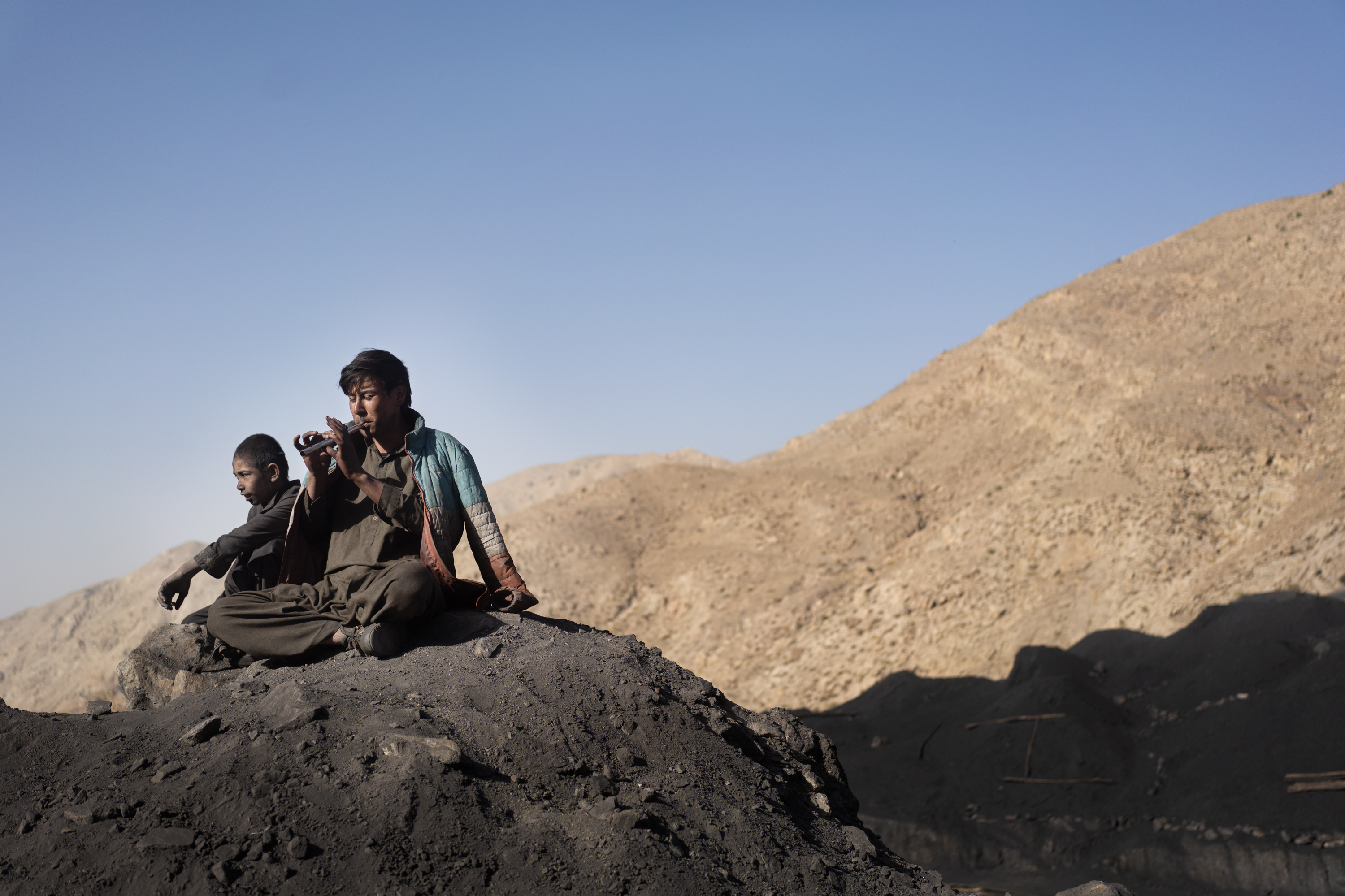 In Afghanistan, coal mining relies on the labor of children 11 Boys sit on the mountain after a 10-hour work day and play the flute.